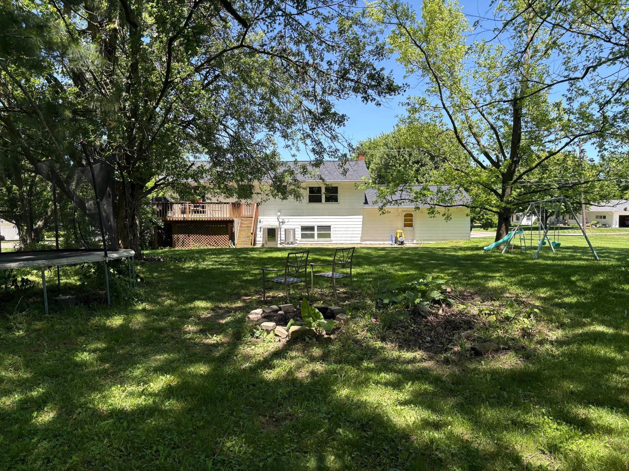 View of generous yard with mature trees.