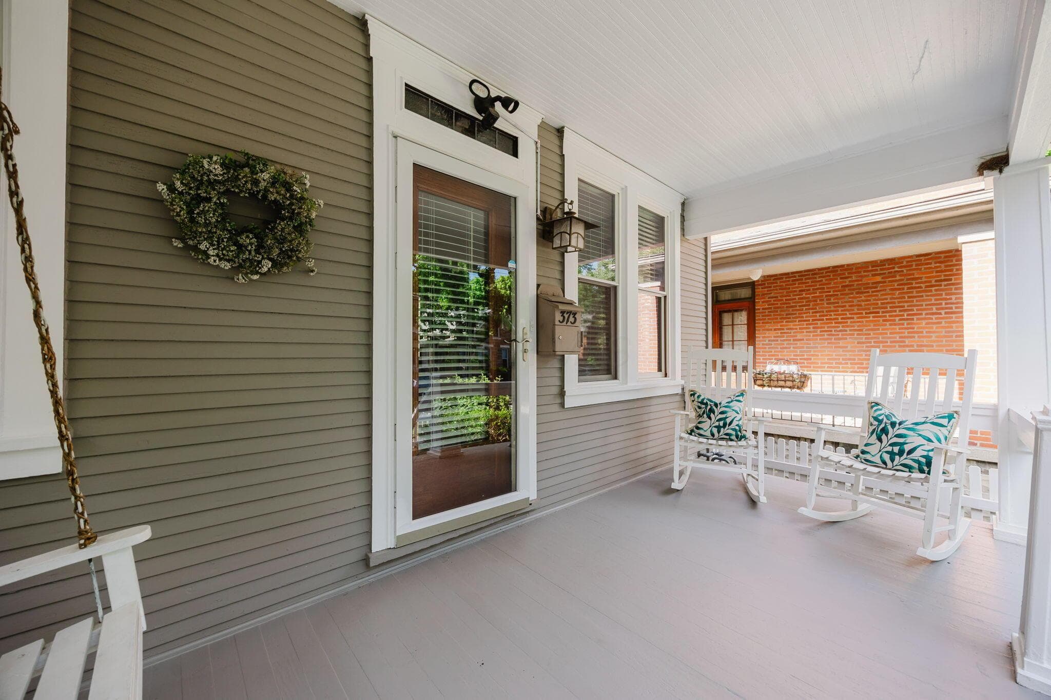 Large front porch with enough room for a swing and chairs.