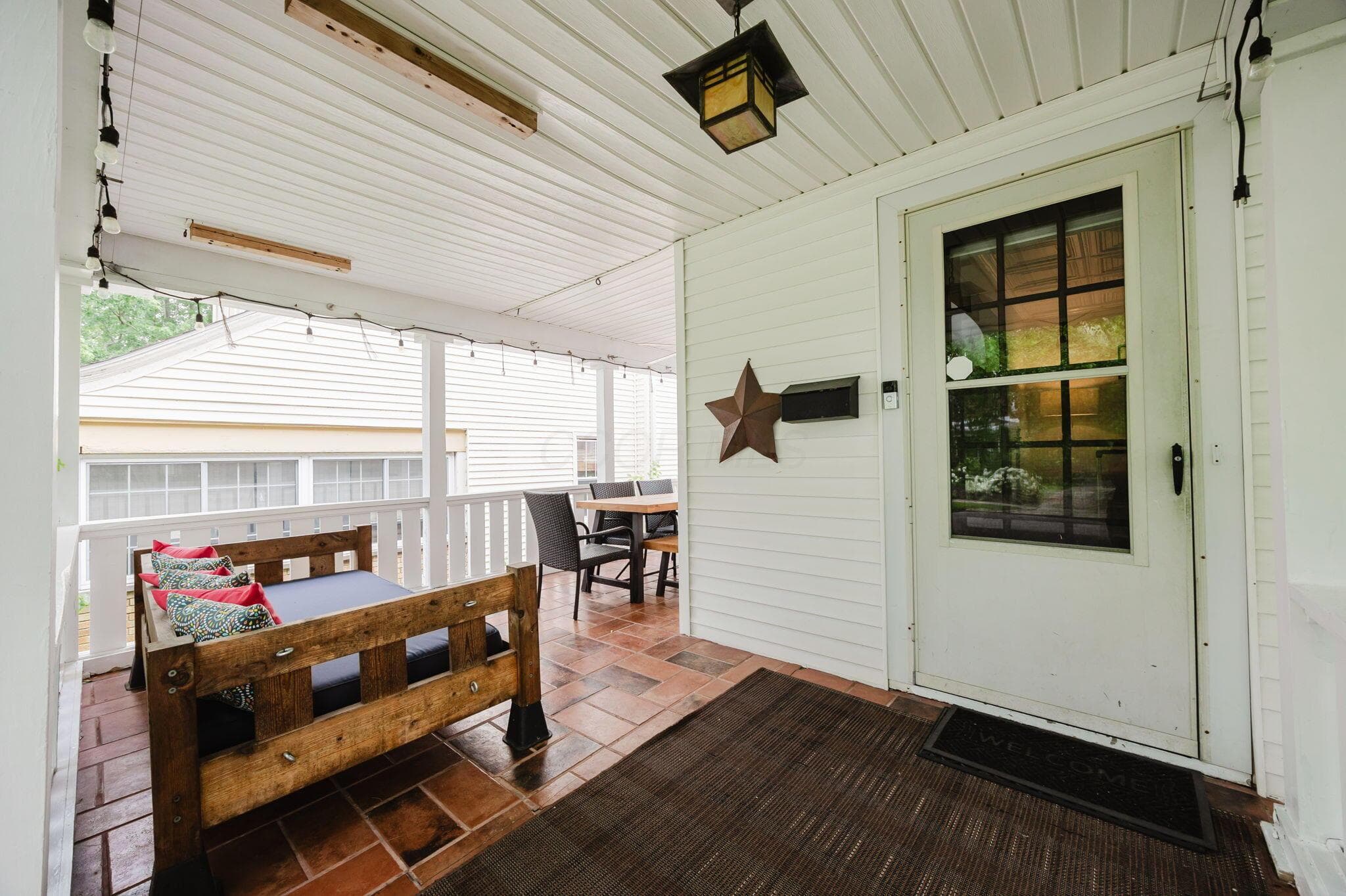 Large front porch with tile and ceiling fan.