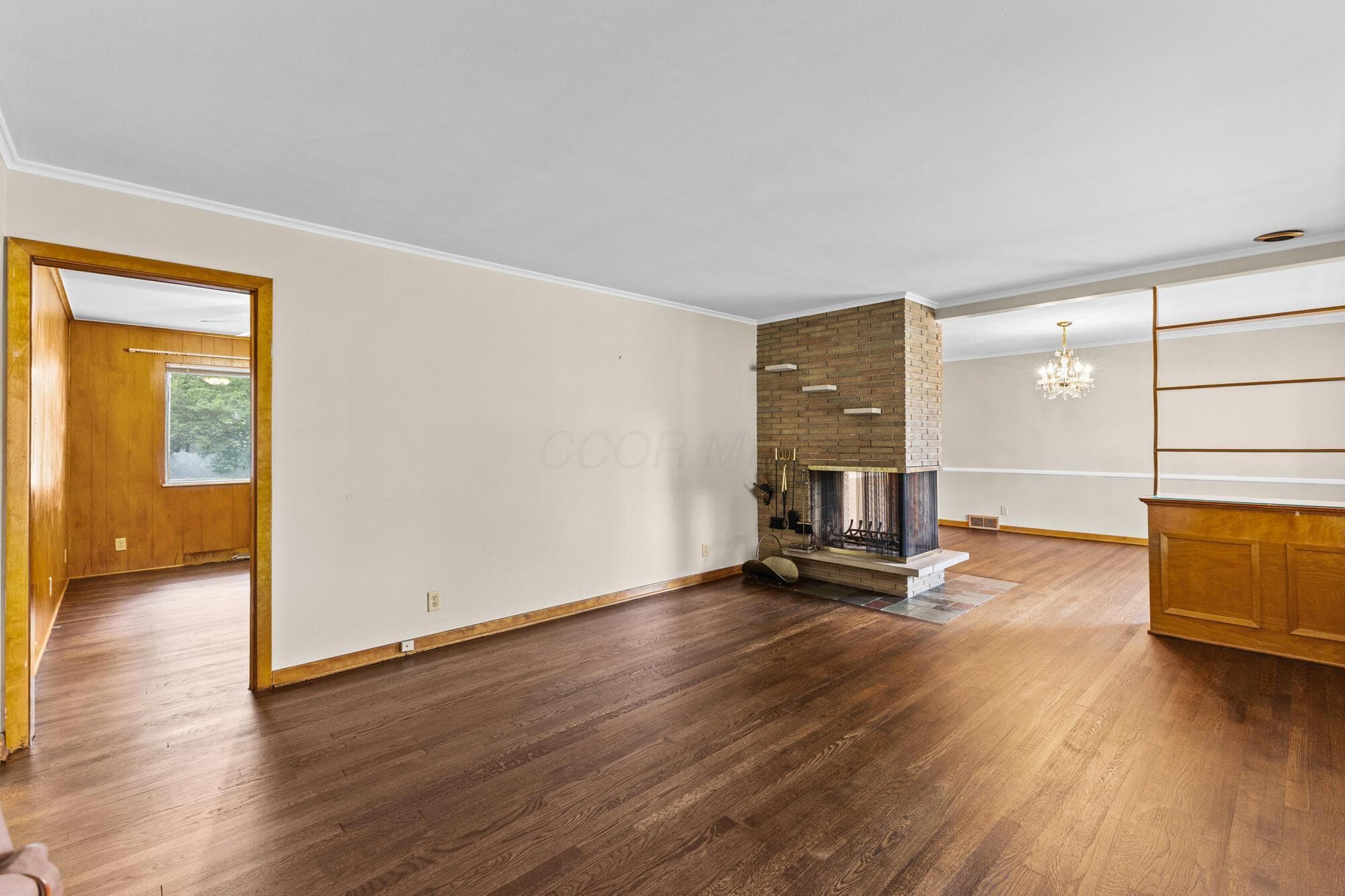 Spacious living room with a gas wood-burning fireplace, hardwood floors