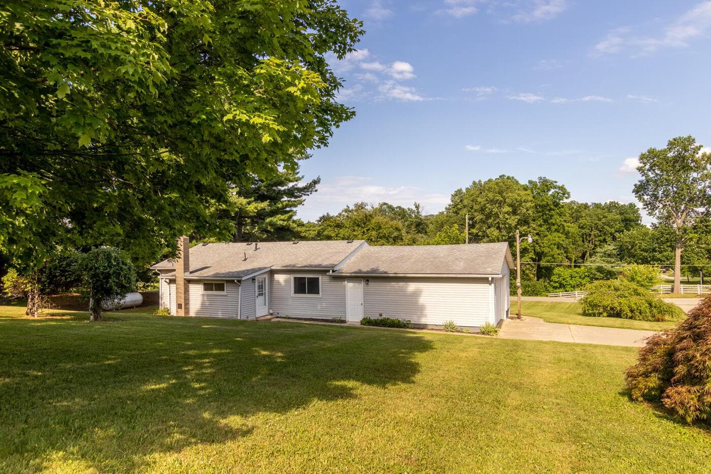 View of back of home and concrete driveway with turnaround