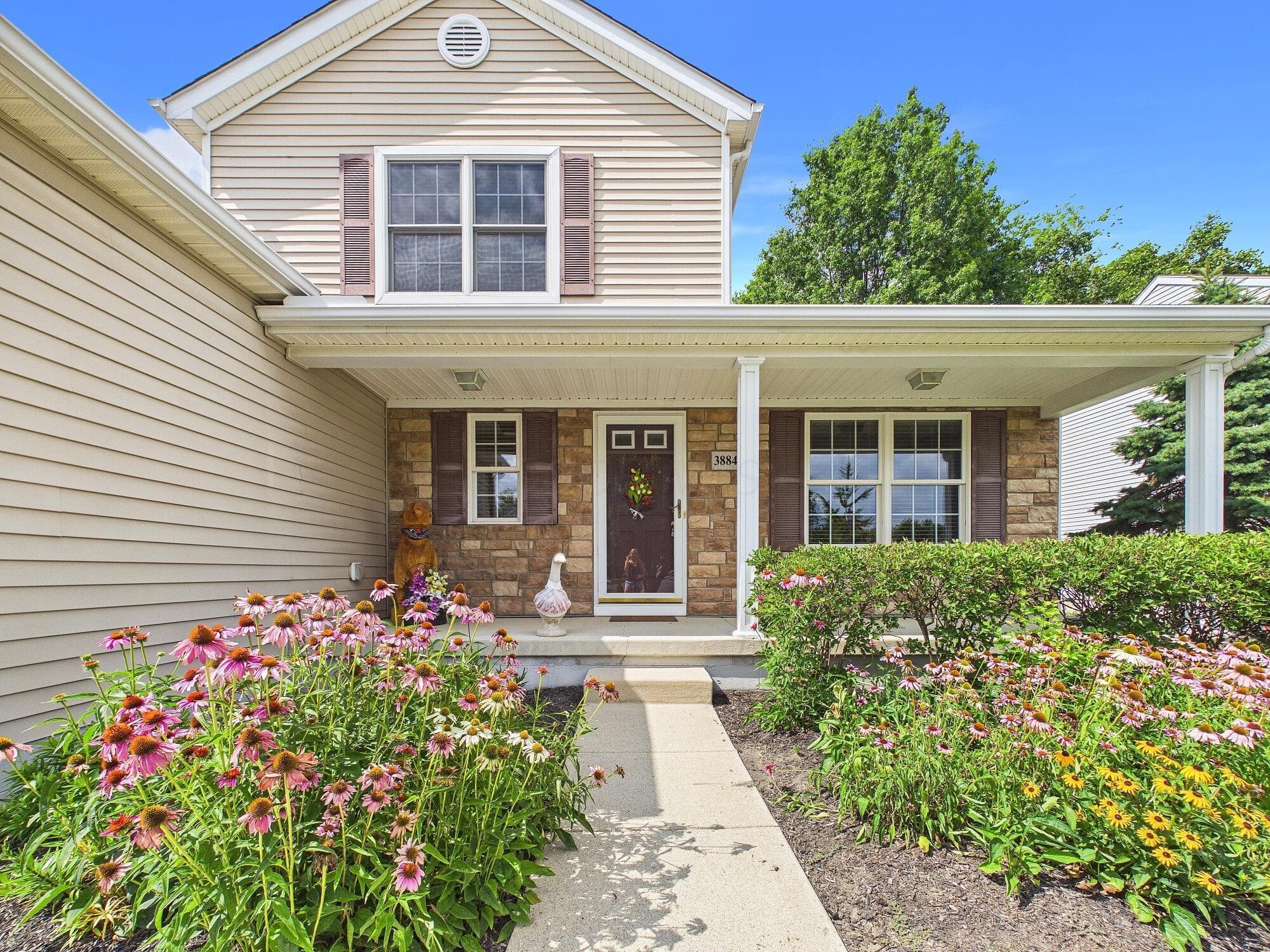 Covered front porch with stone accents and decorative shutters