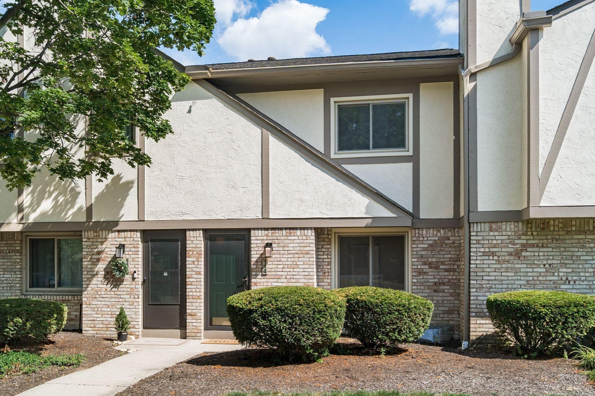 Exterior featuring a brick lower level, stucco upper level, and wood trim