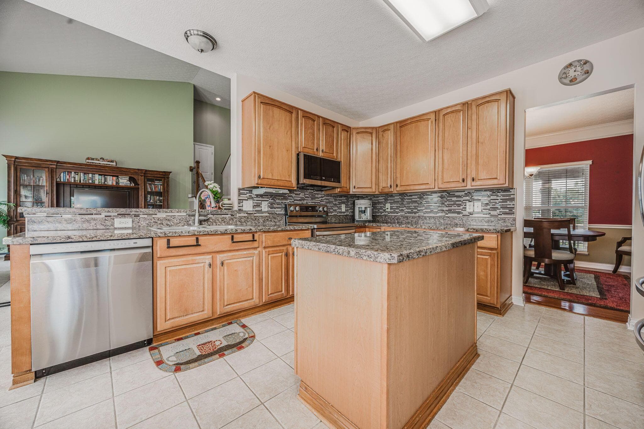 Spacious kitchen with center island, ample cabinetry and stainless steel appliances.