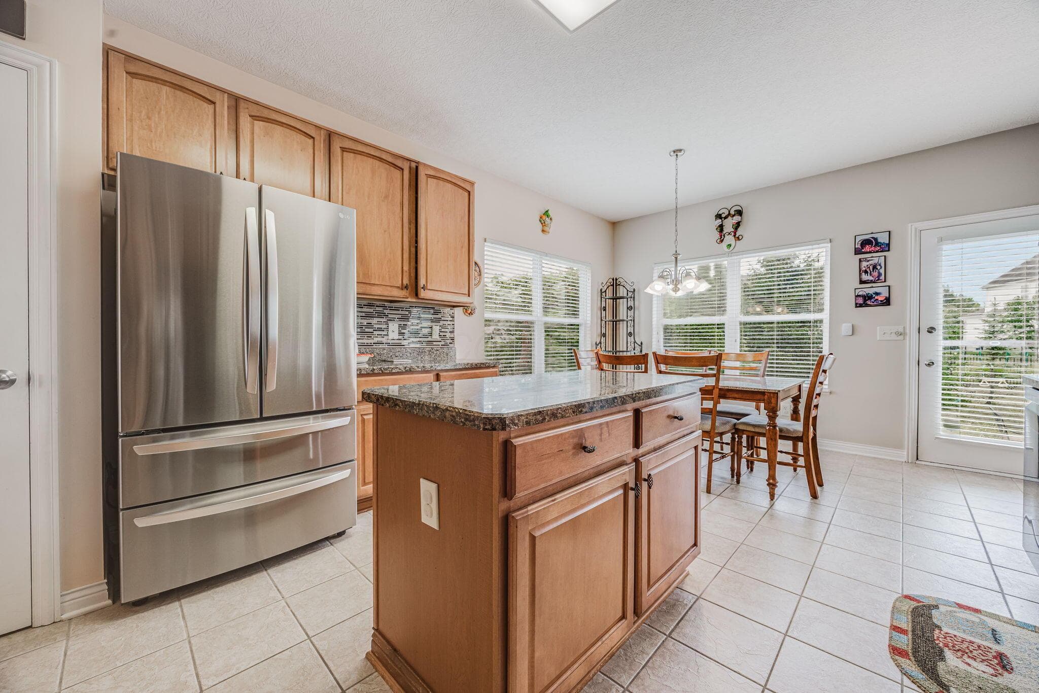 Additional kitchen view highlighting the island and adjoining casual dining space.