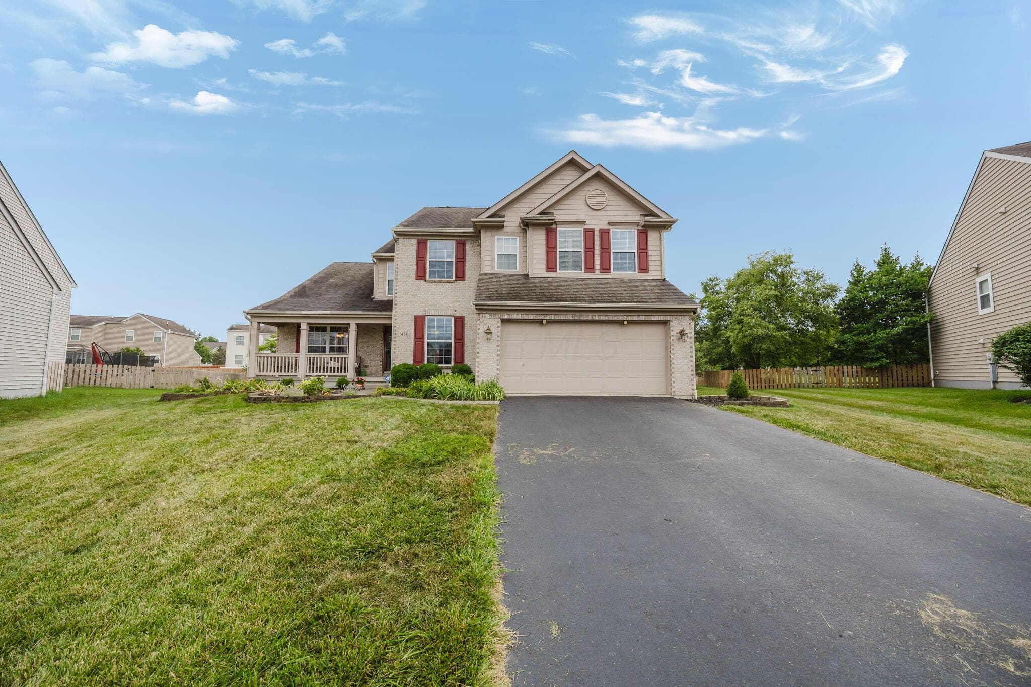 Attractive front exterior with spacious driveway and landscaped yard.