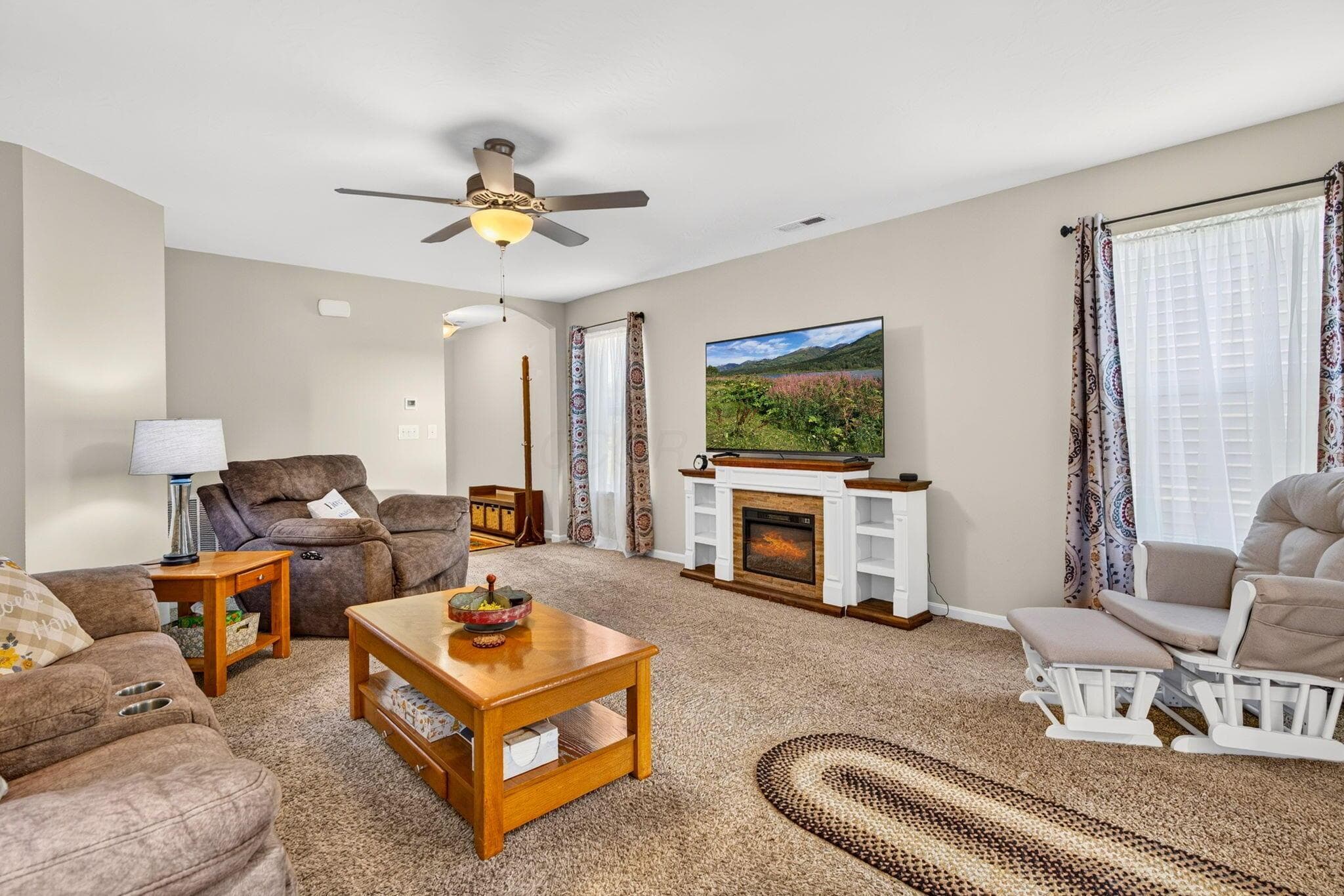 Generously sized living room with a ceiling fan and flexible space for comfortable everyday living or entertaining.
