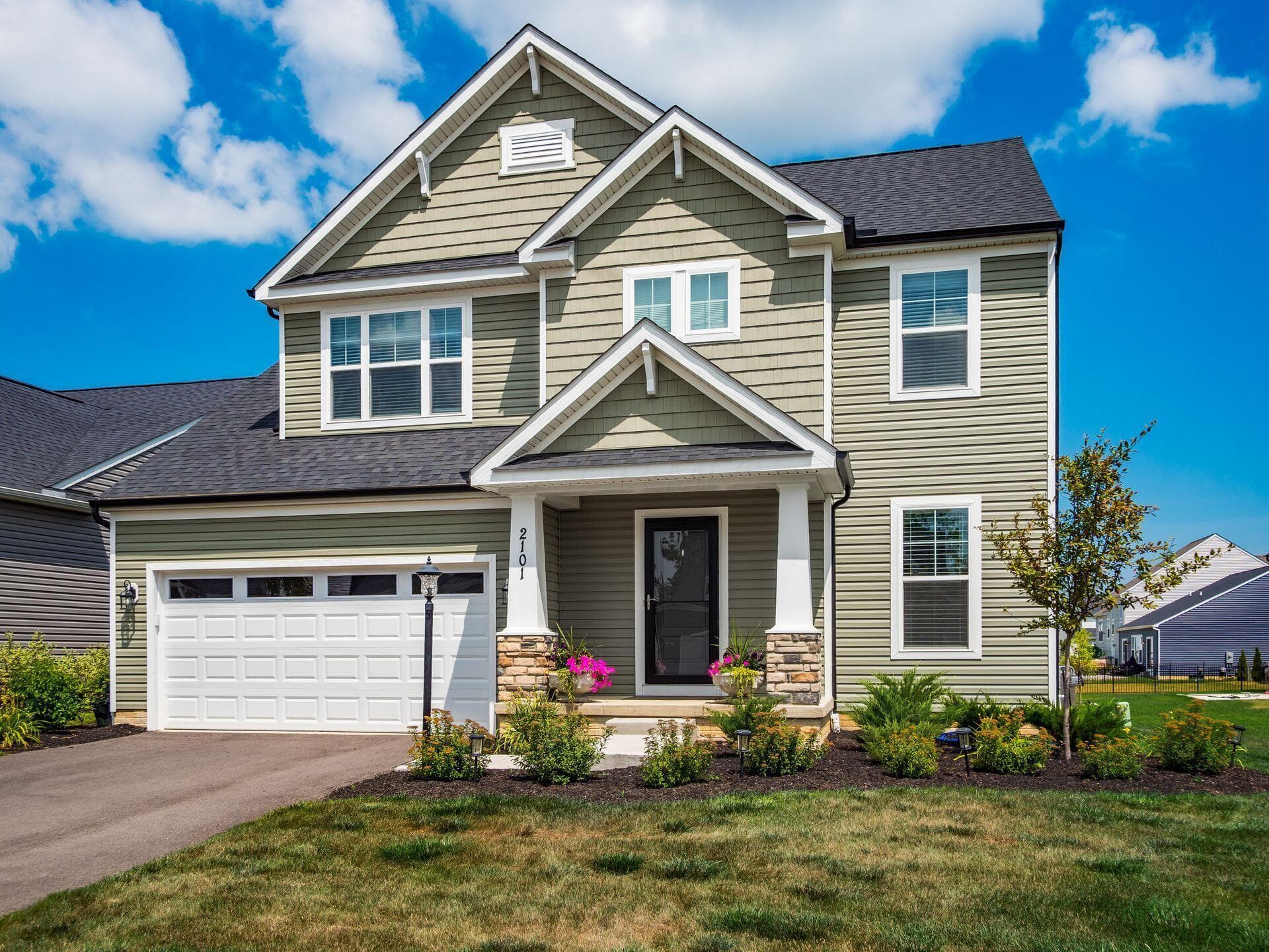 Contemporary two-story residence with a covered front porch featuring stone-wrapped columns