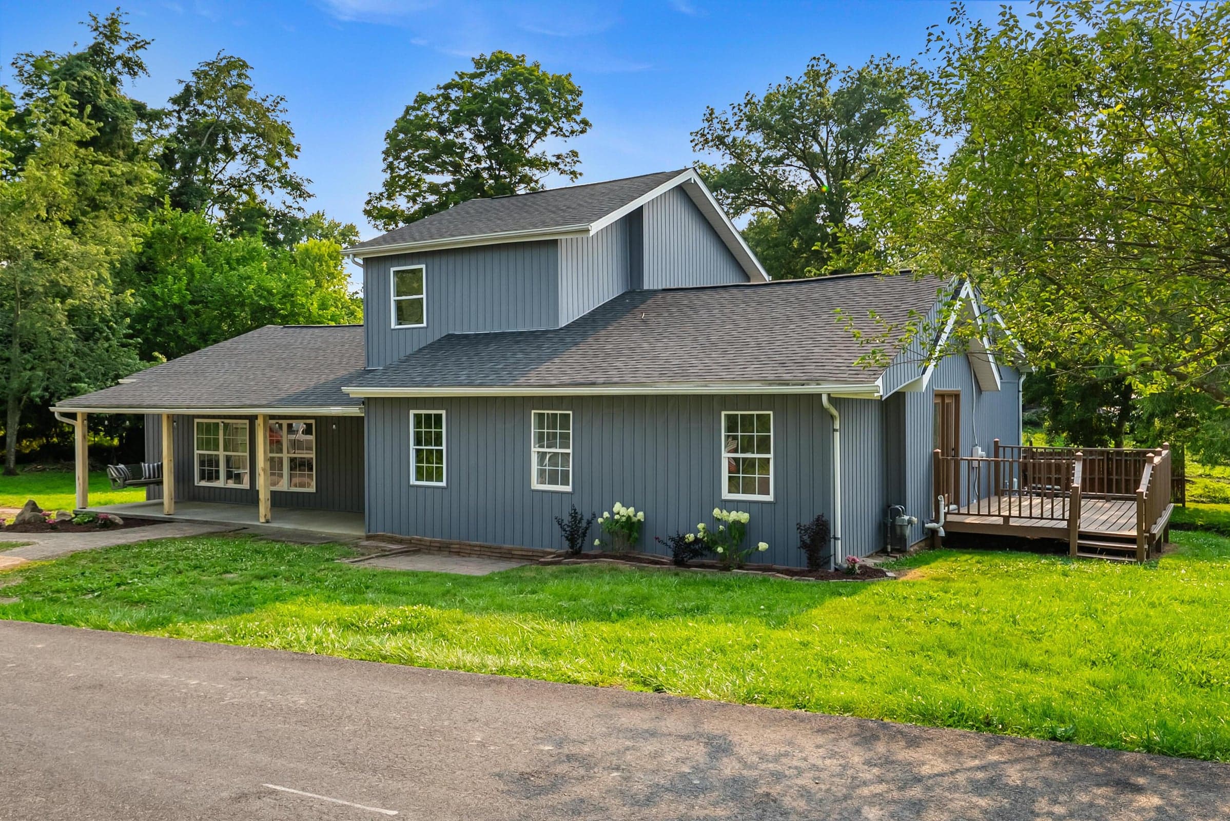 Large front facing Pine Road view featuring wooden deck off of kitchen.