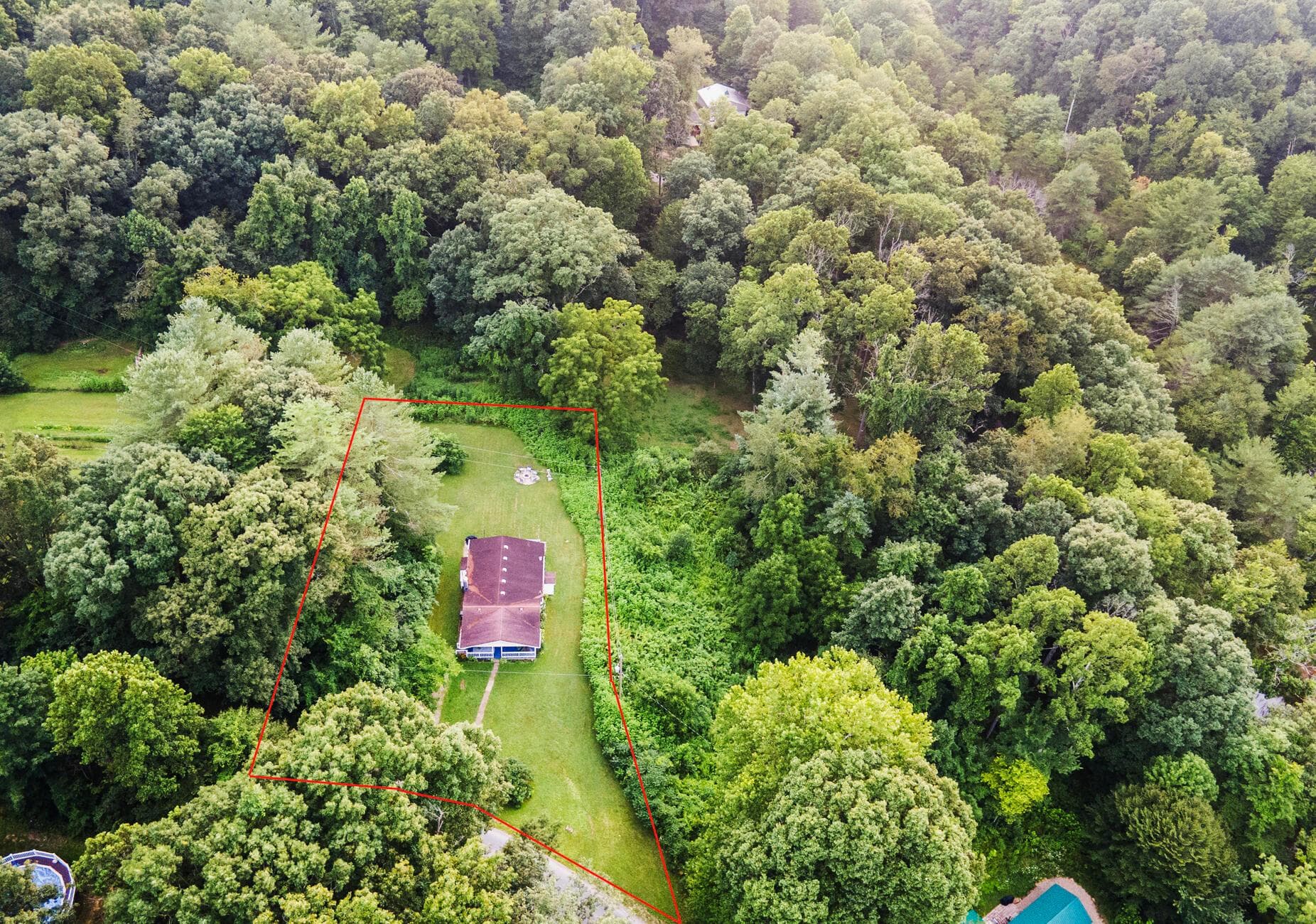 Cottage is surrounded by woods.