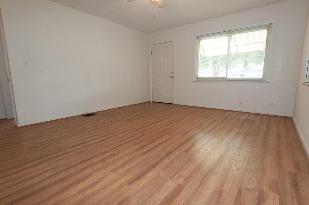 Spacious family room featuring wood-finish flooring and freshly painted walls