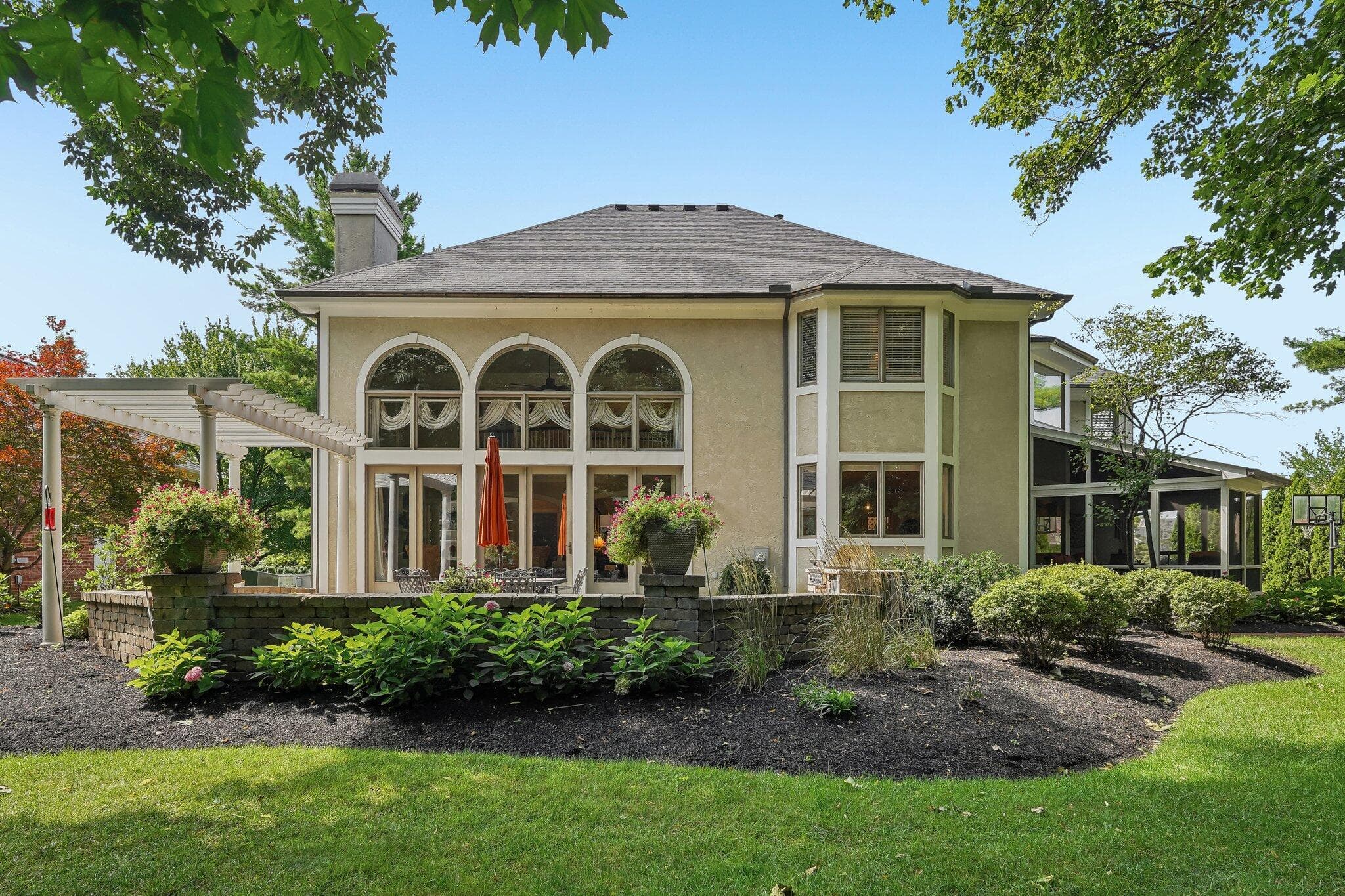 Rear elevation showcasing the patio, pergola, and screened porch.