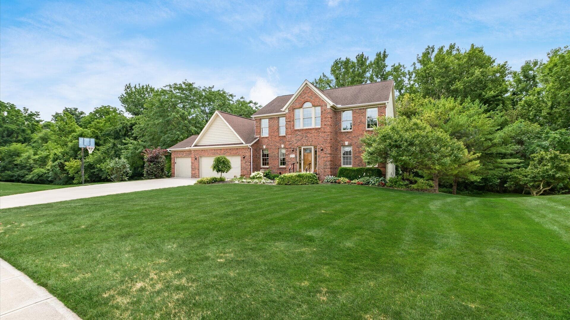 Brick two-story residence with a multi-gabled roofline and a three-car garage