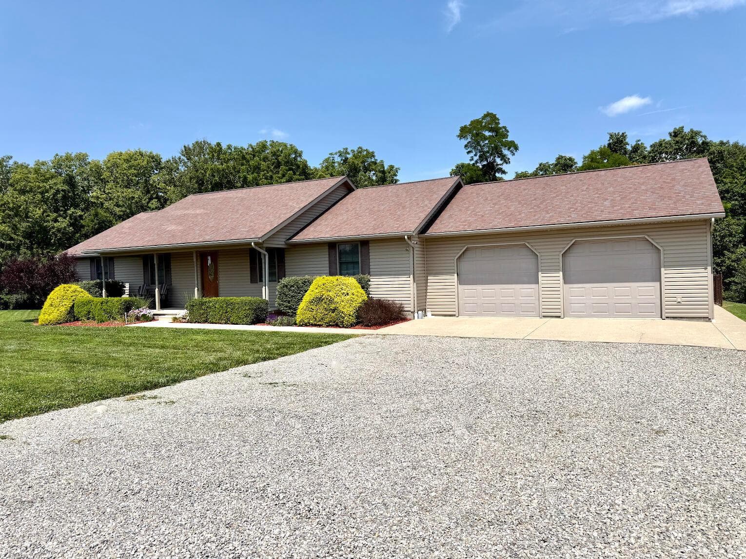 Ranch-style residence featuring beige siding and a brown shingle roof