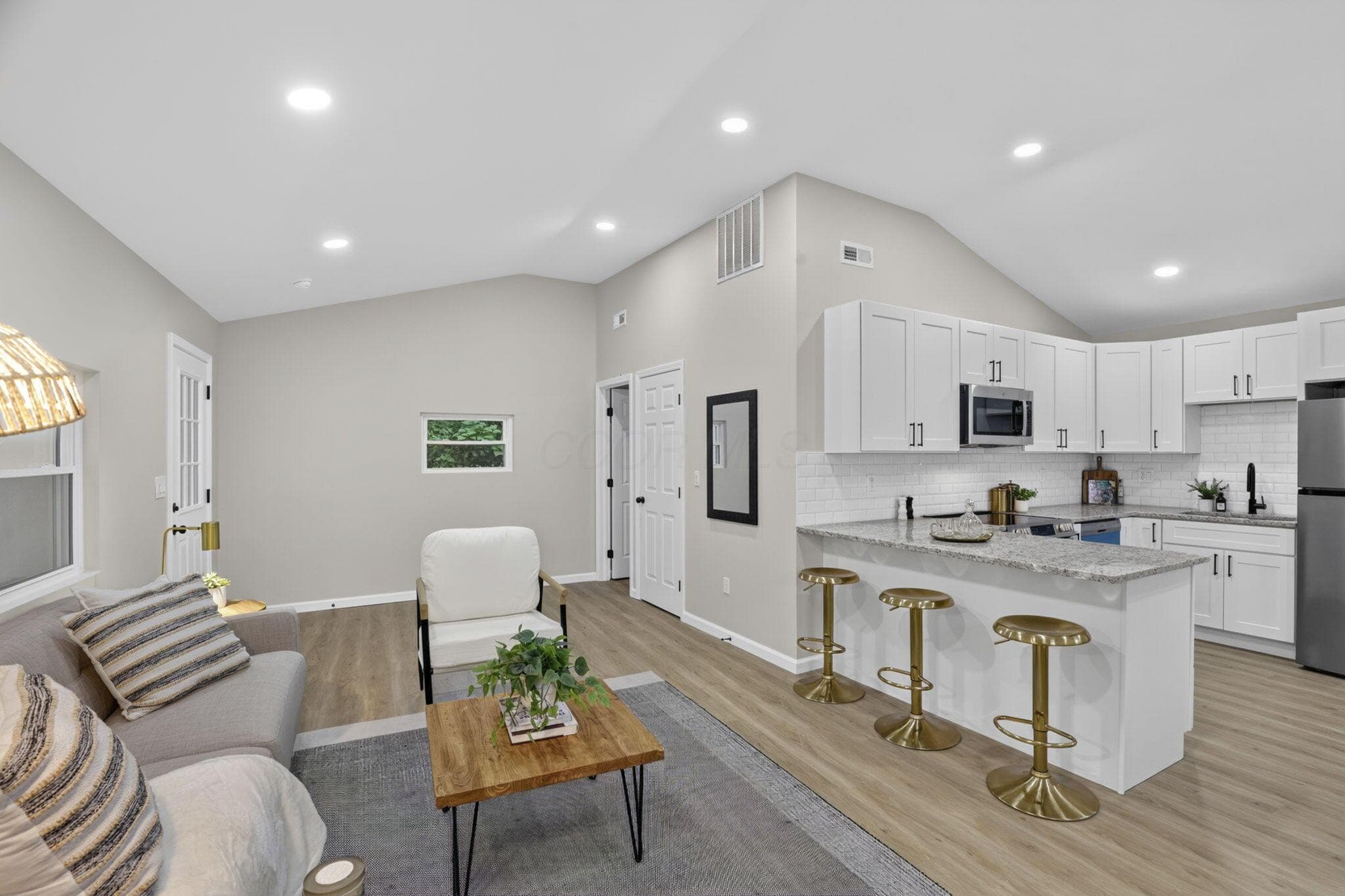 Open-concept living area with vaulted ceilings and recessed lighting