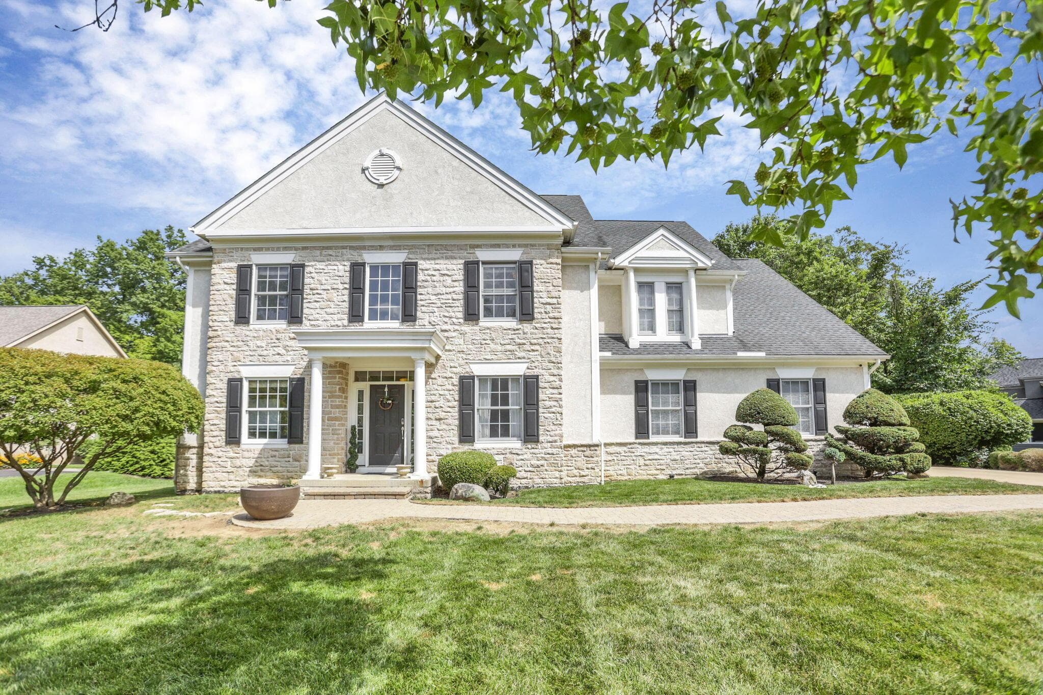 Stone and stucco exterior with multiple gables