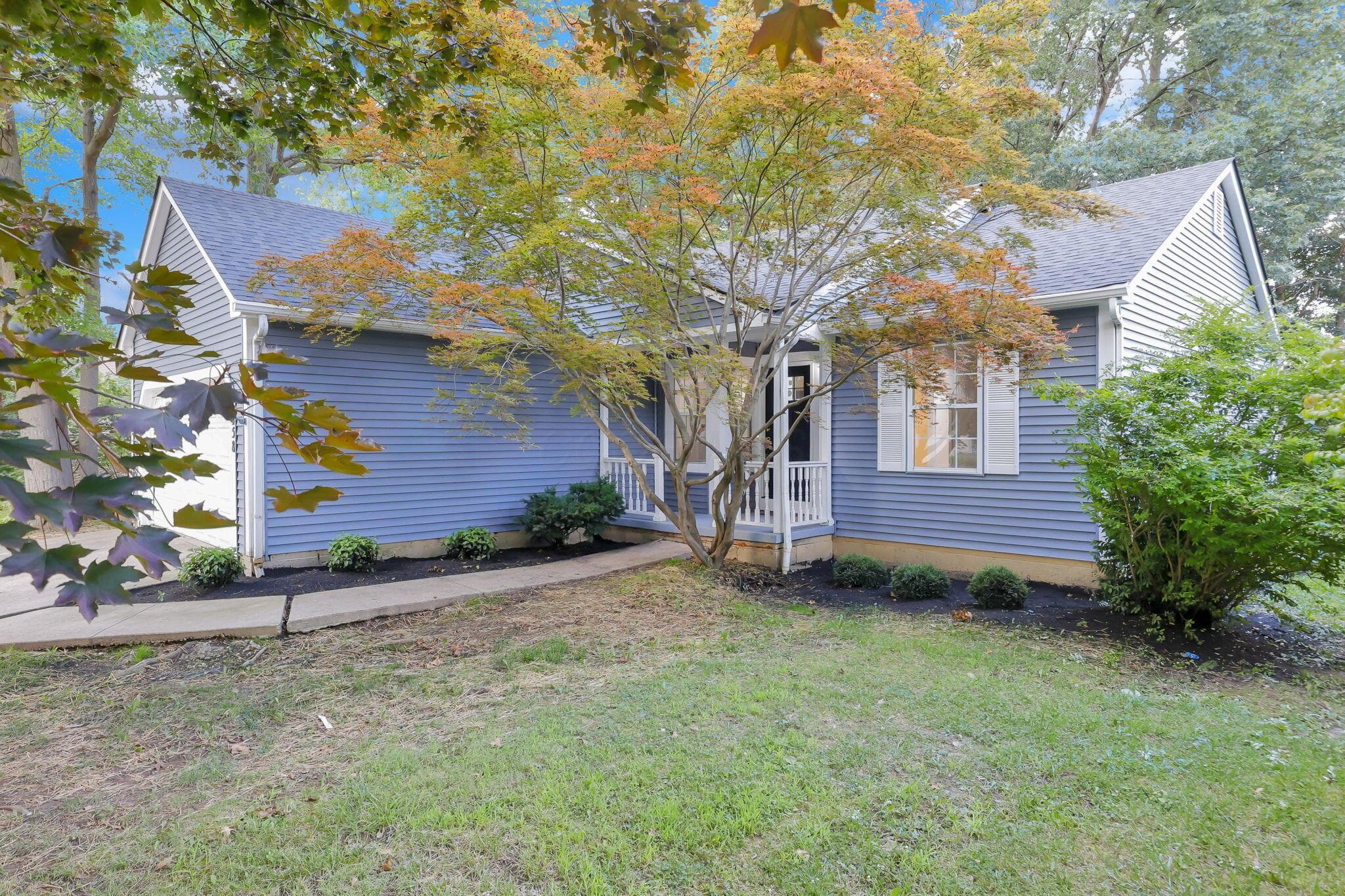 Blue vinyl siding with white trim, a covered entry, and a prominent front-facing window