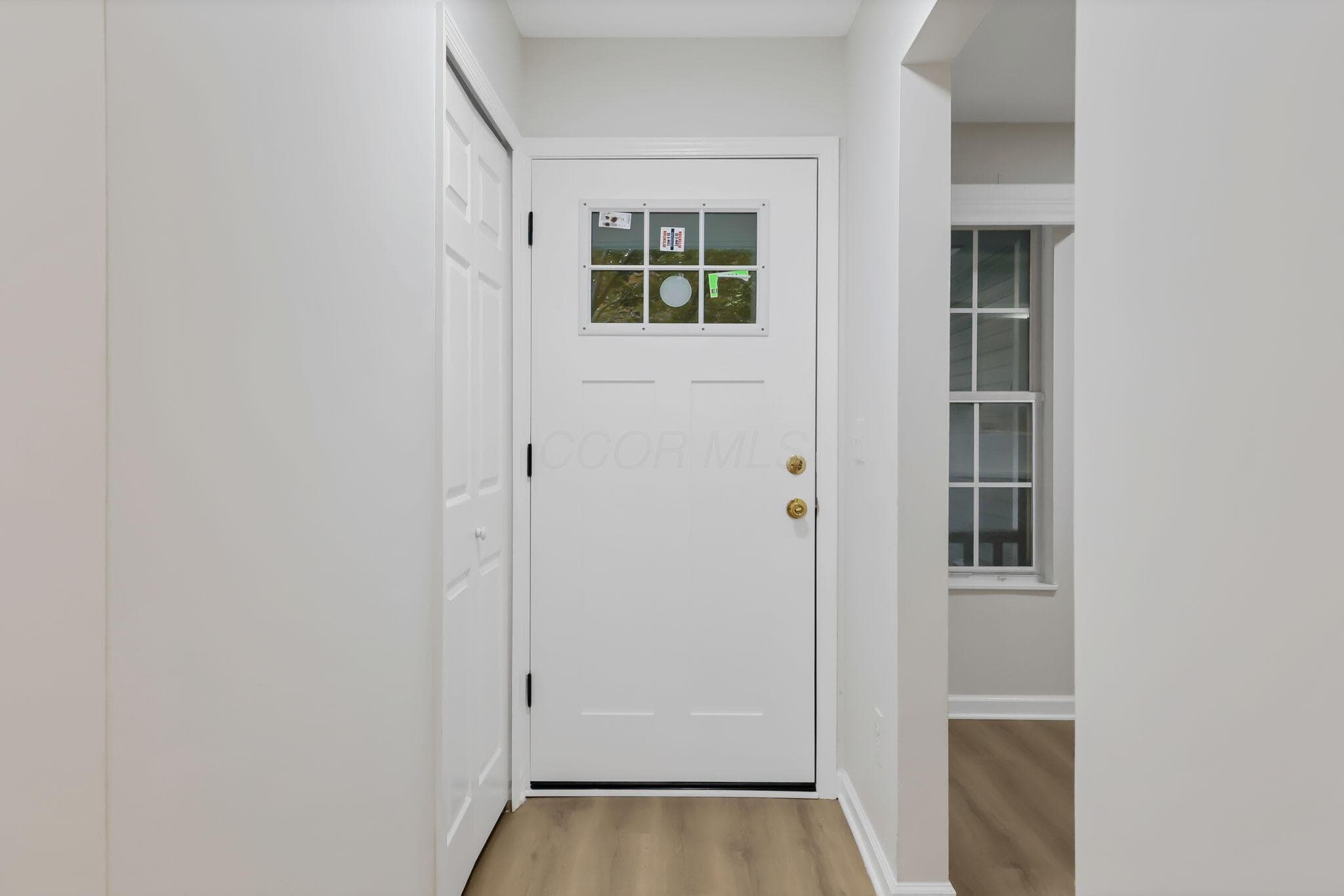 Entry door with clear-paned window grid and brass hardware