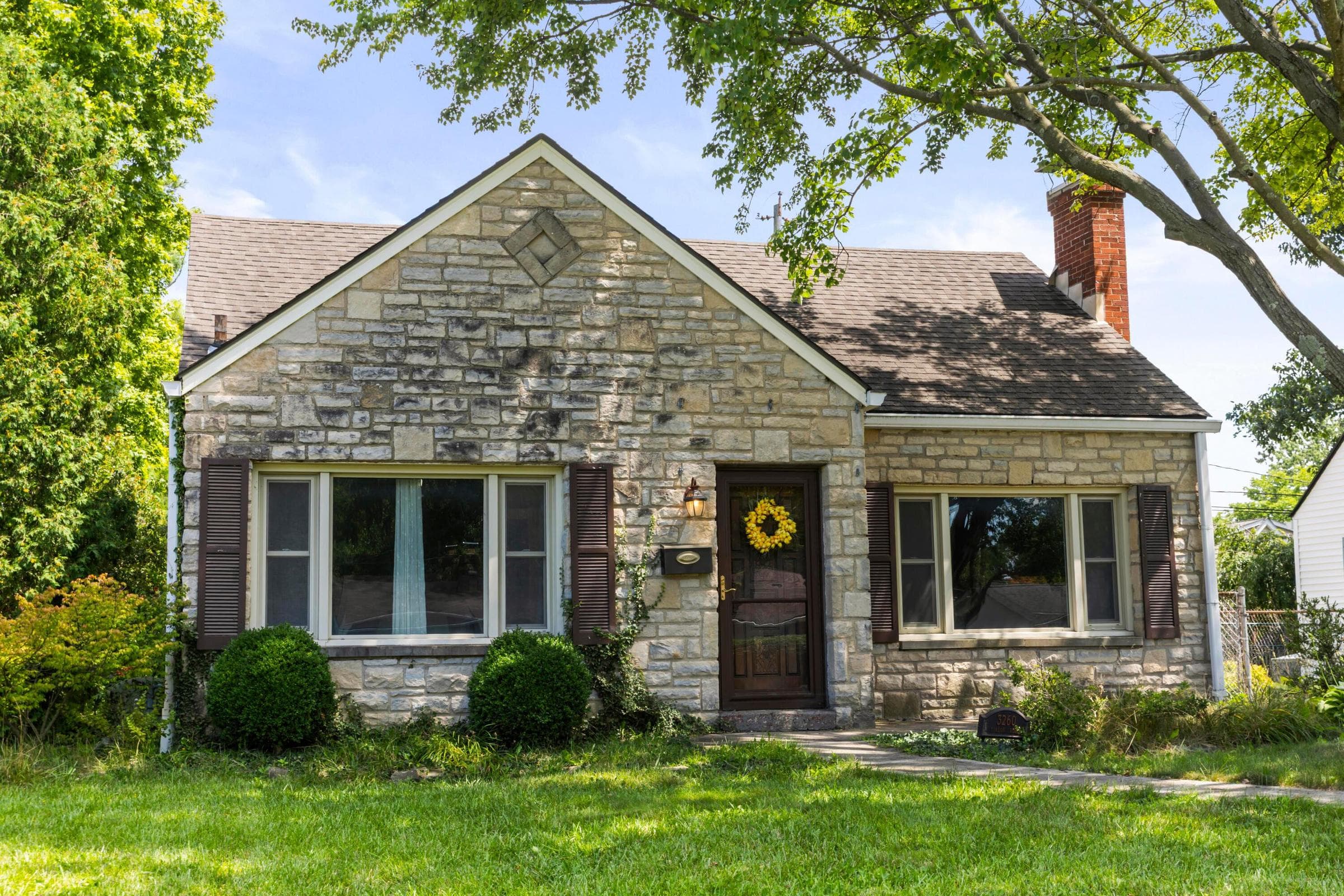Stone exterior with shutters, and a brick chimney