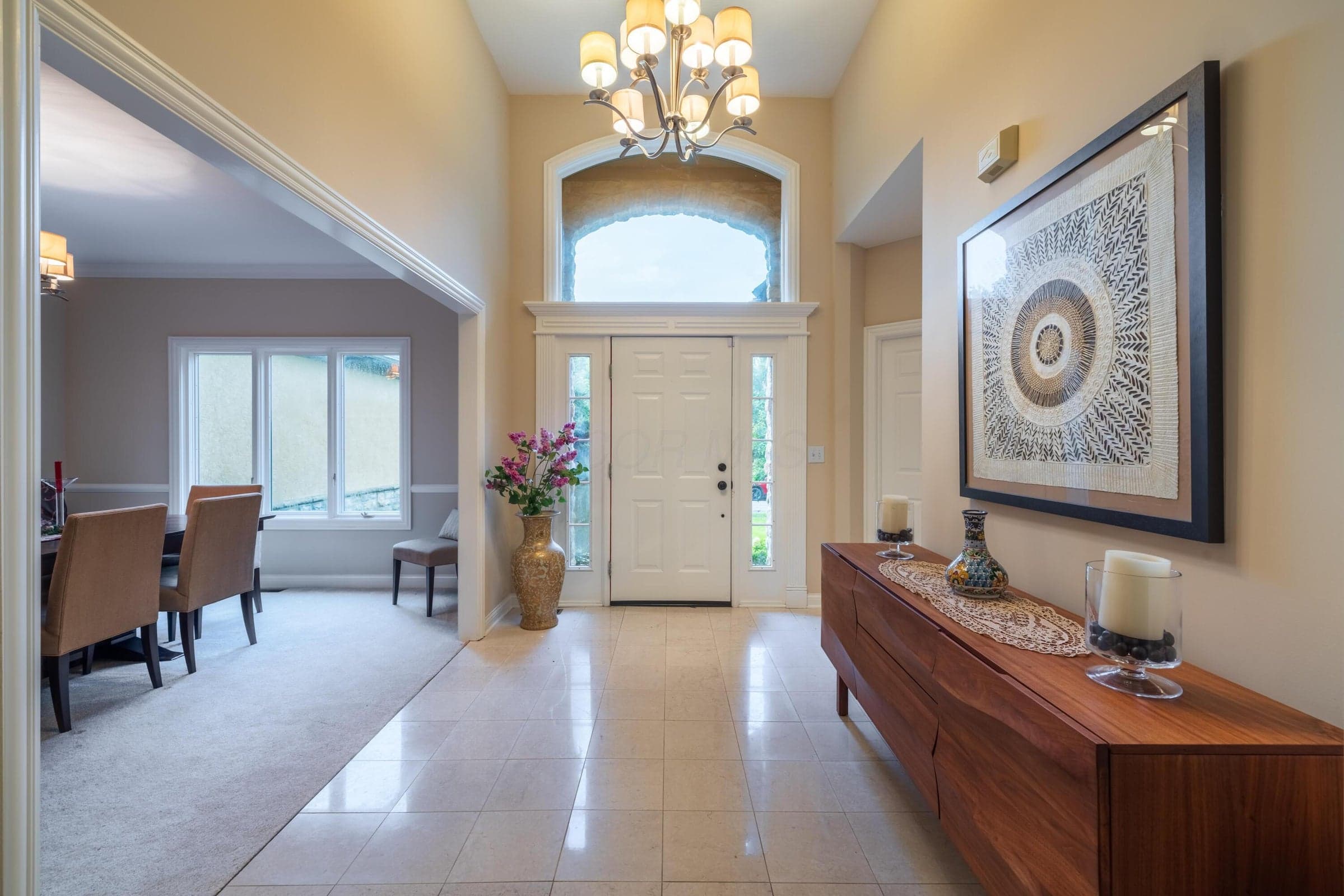 Impressive two-story entry with abundant natural light and an open view into the formal dining room.