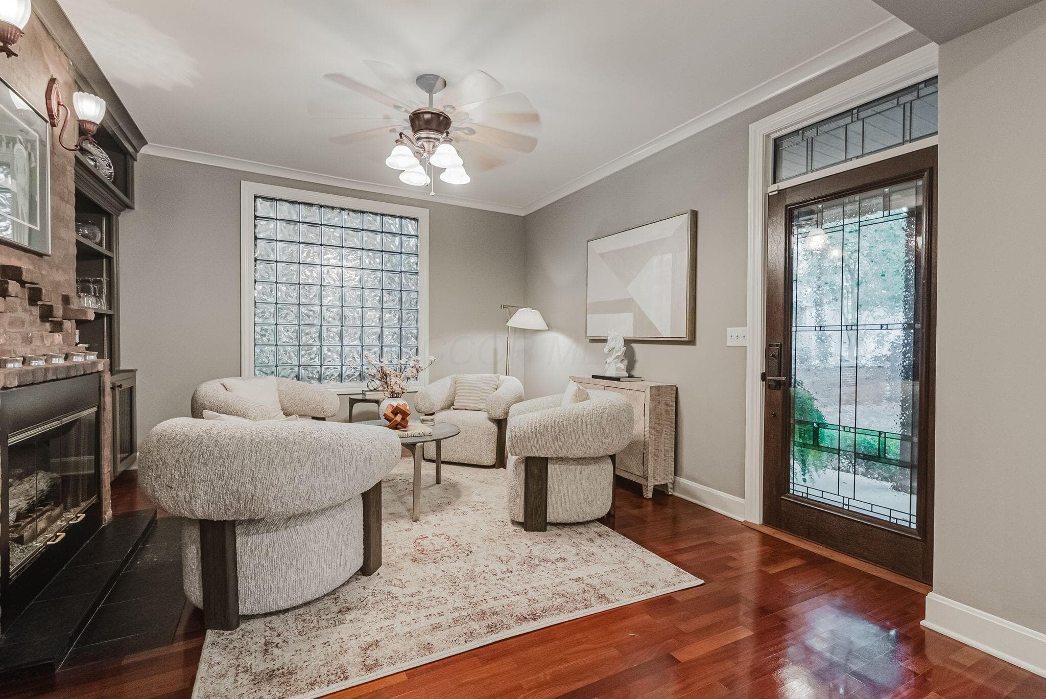 Hardwood flooring, fireplace with brick surround and built-in shelving,