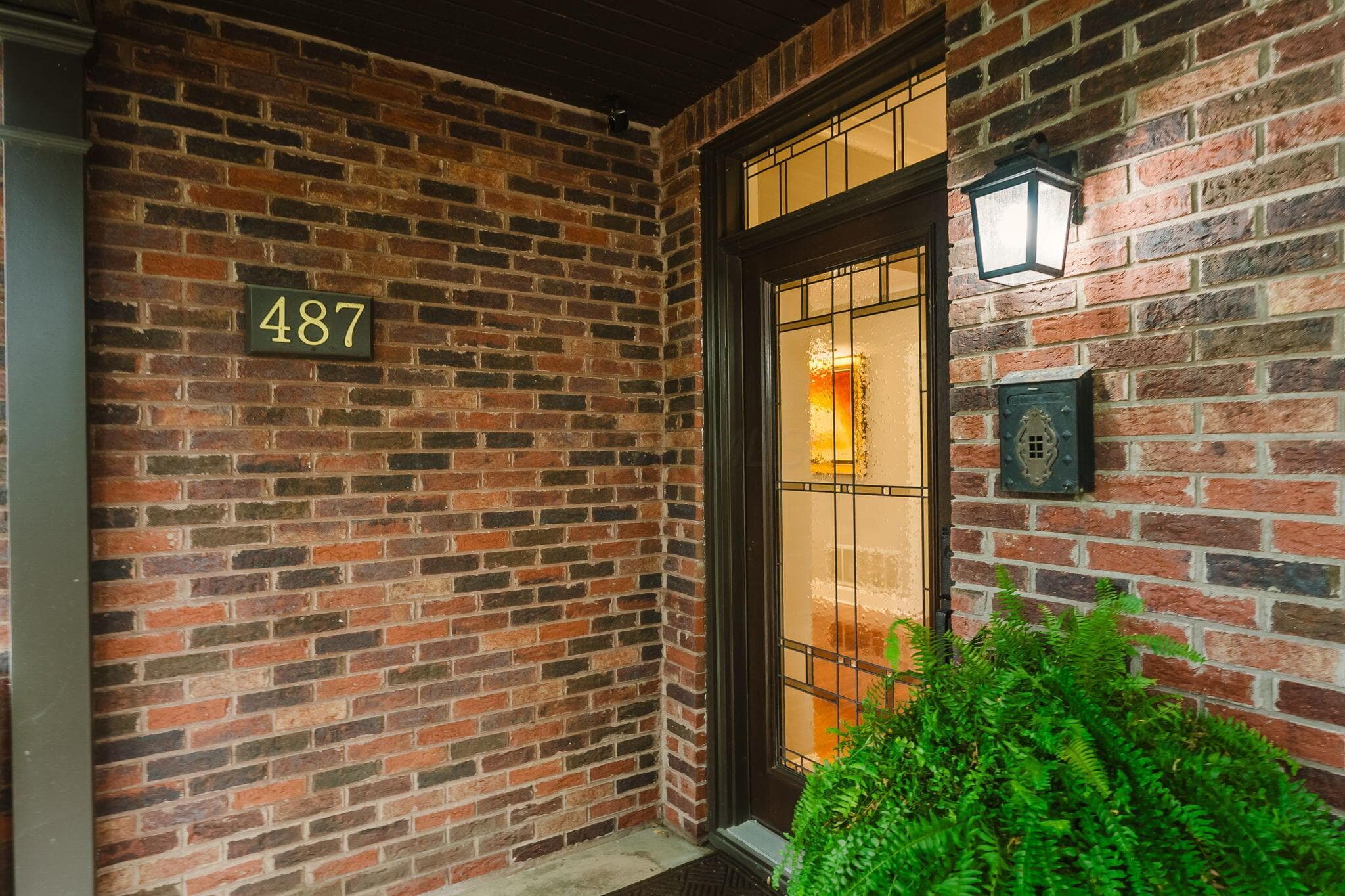 Brick exterior with a beautiful entry door.