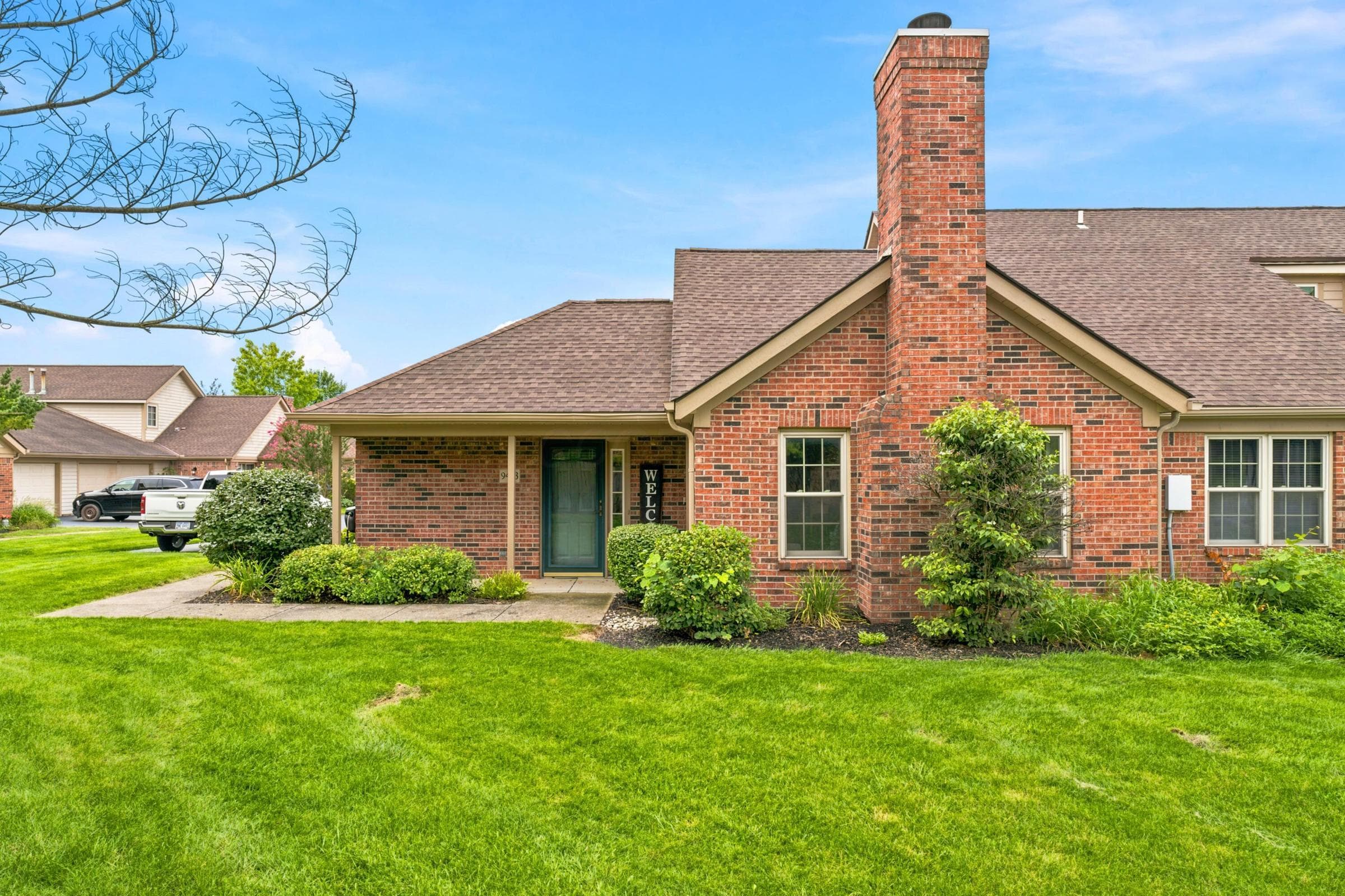 Brick exterior with an integrated chimney, gabled rooflines, and a covered entry