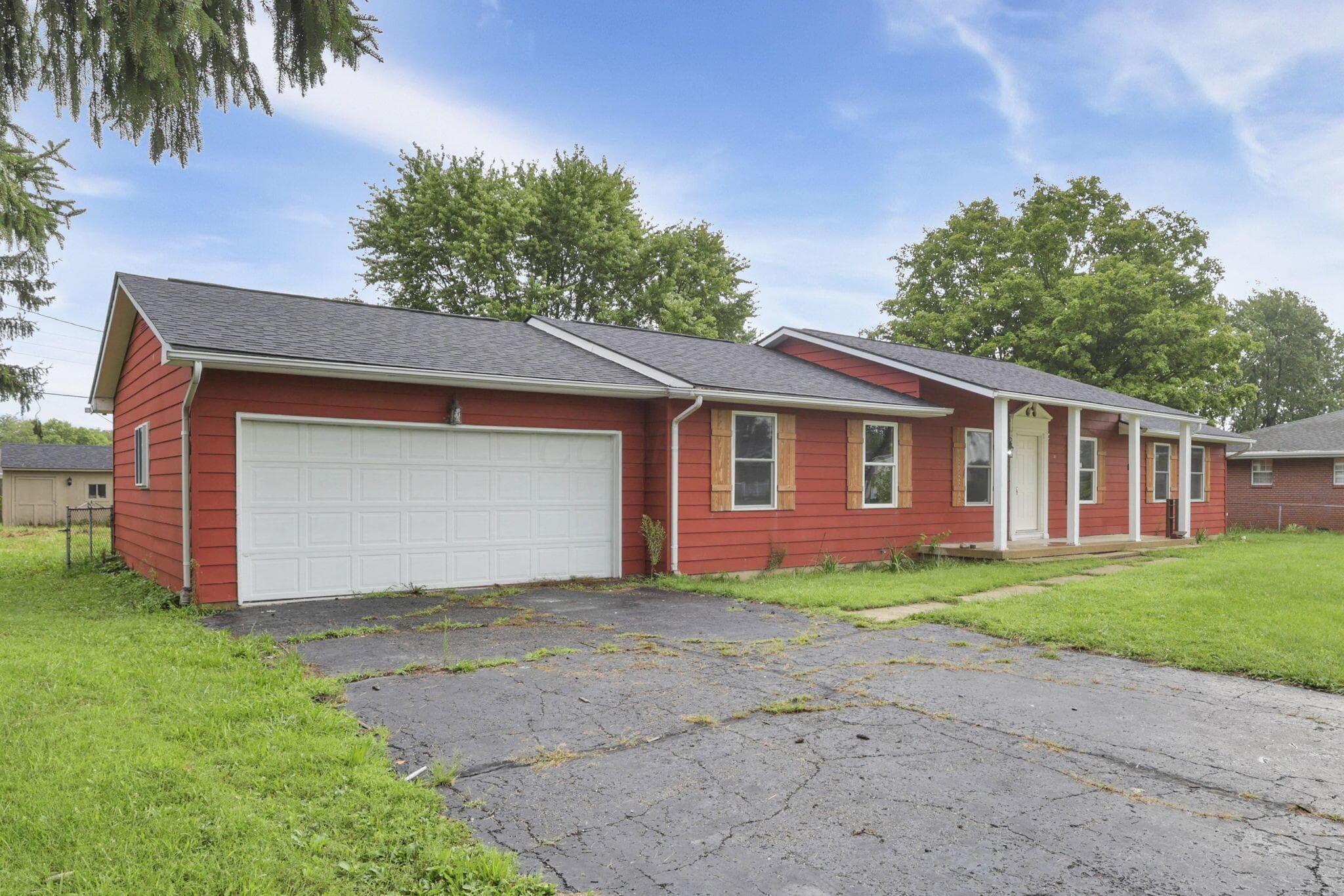 Red siding exterior with a dark shingle roof