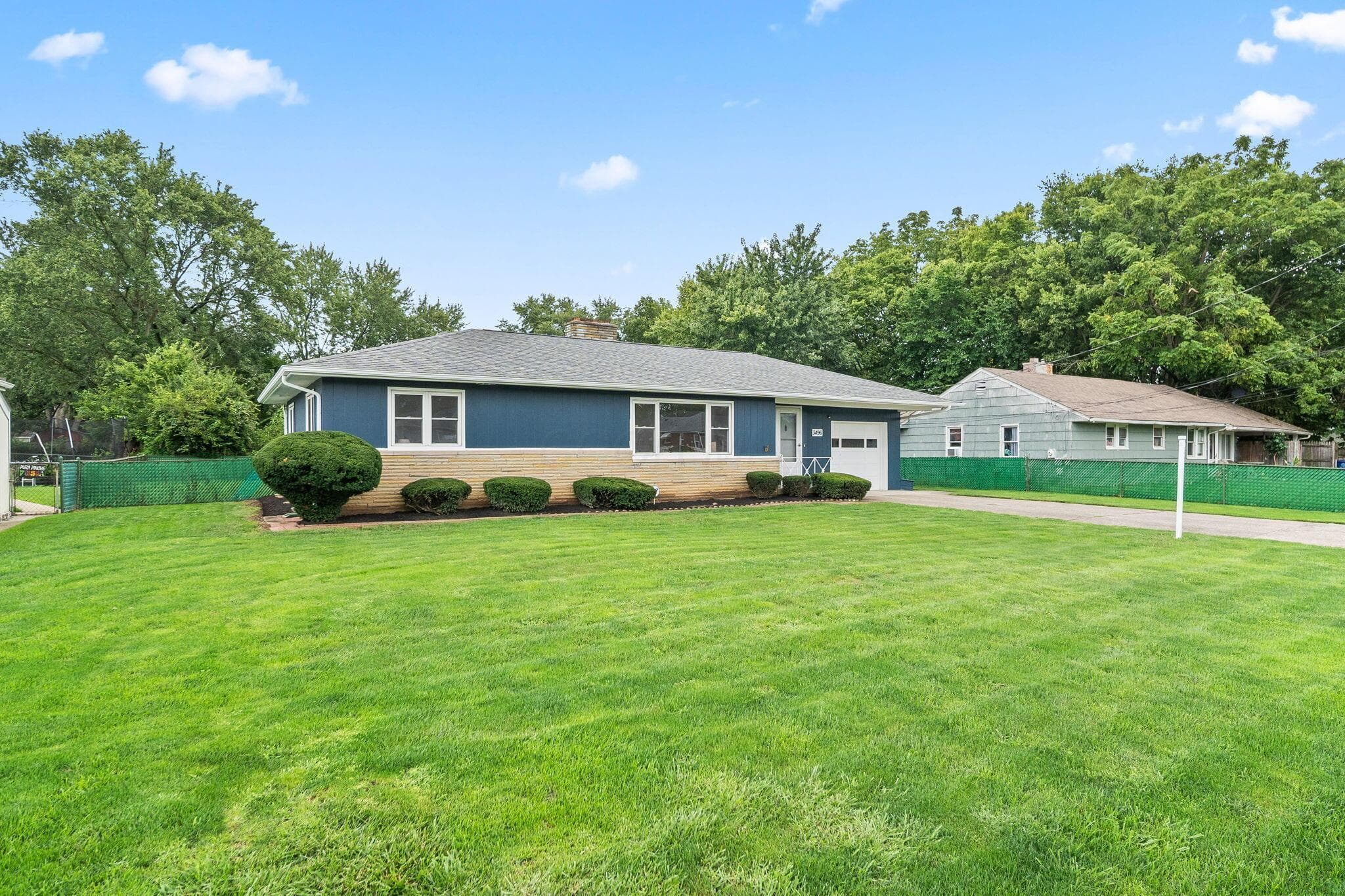 Ranch-style exterior with blue siding and tan brick accents