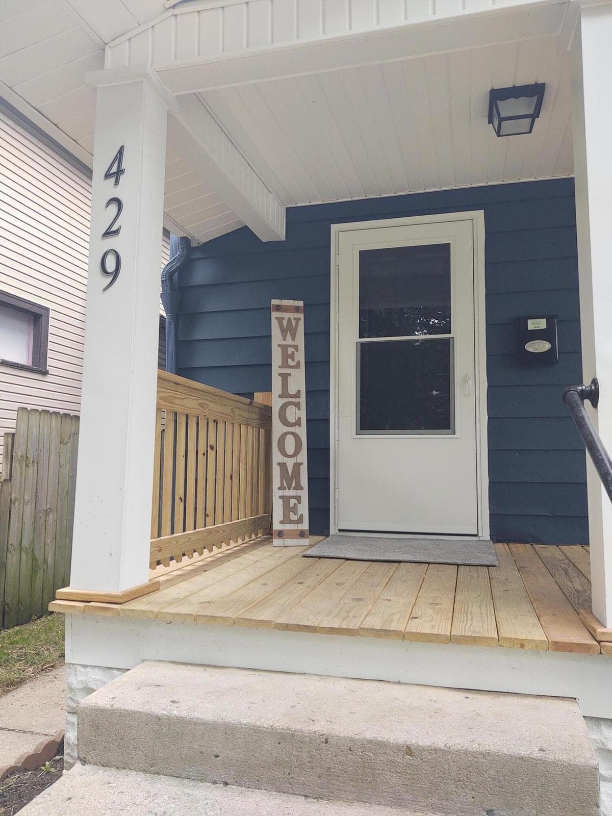 Concrete steps entry to front porch and new storm door. New steel front door too.