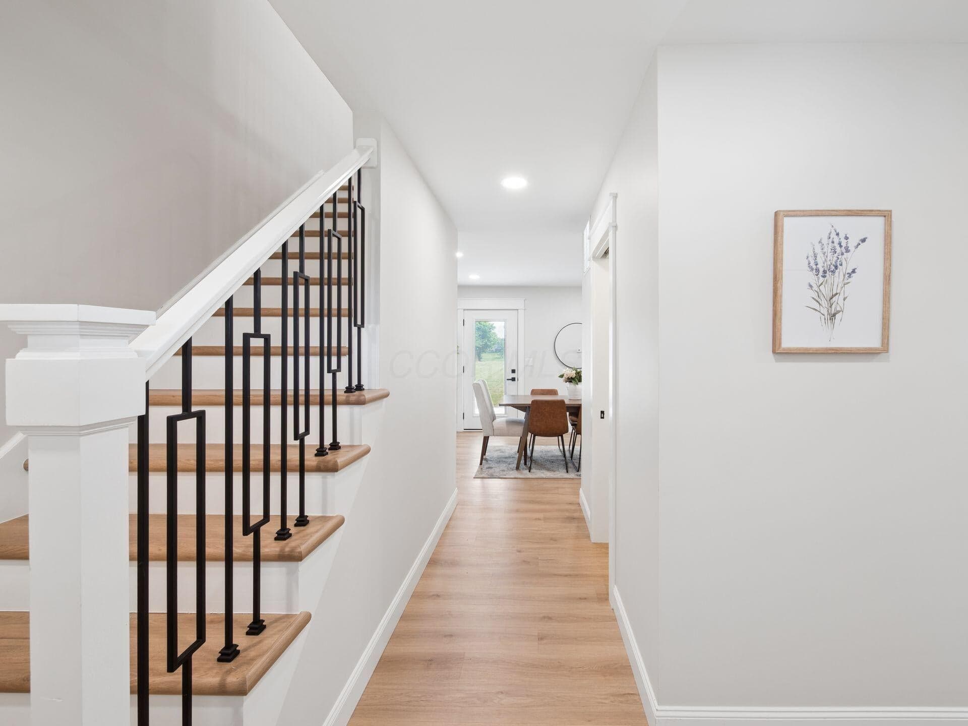 Luxury vinyl flooring flows throughout the first floor, up the steps, and down the hallway.