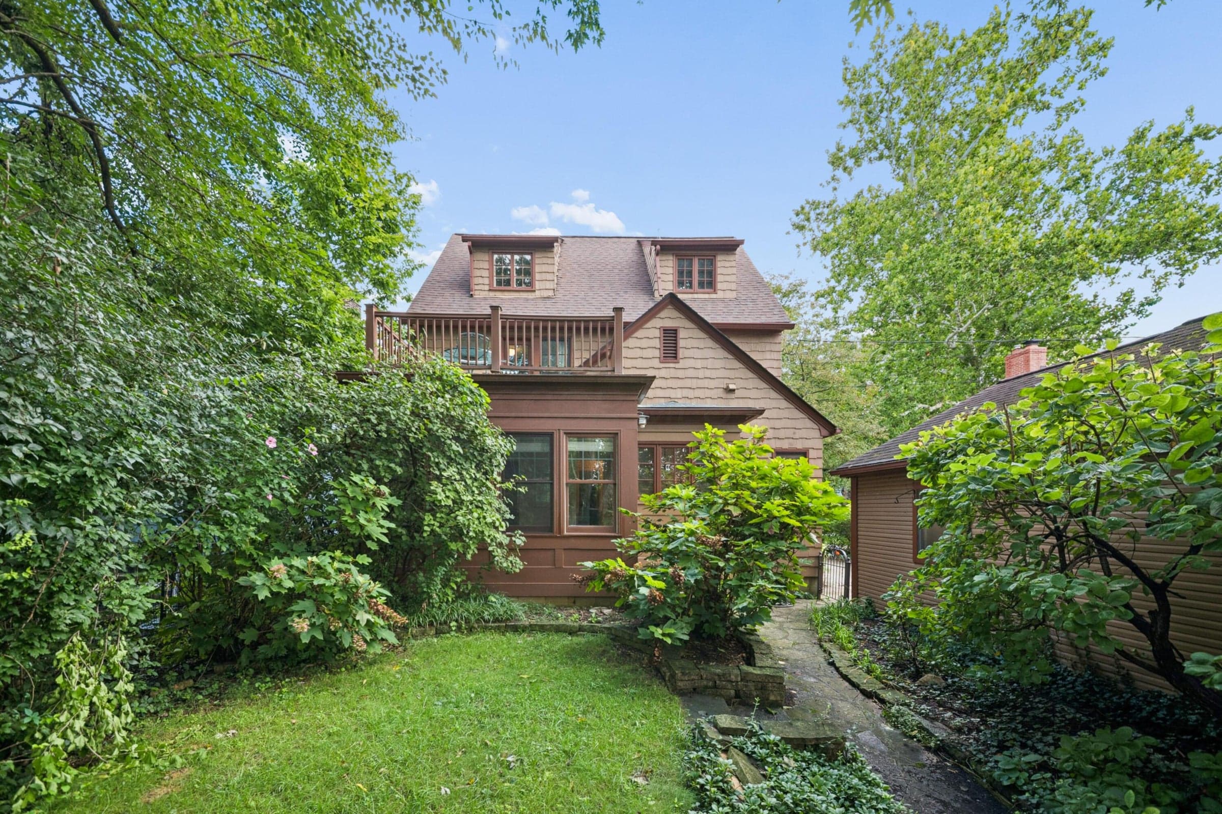View of back of the house including second floor balcony, 4 car garage, sunroom