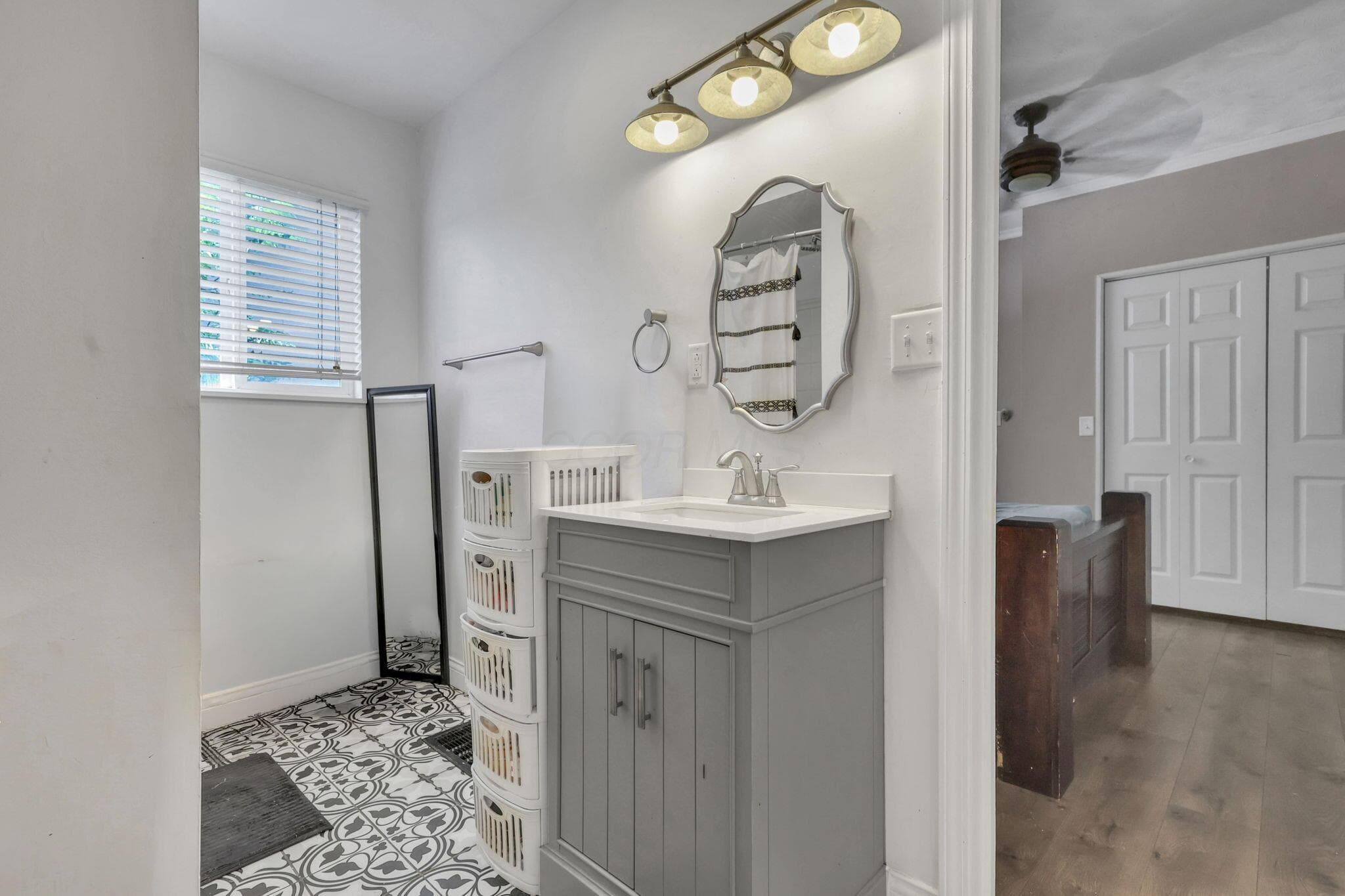 Bathroom featuring a vanity with a white countertop and a decorative mirror