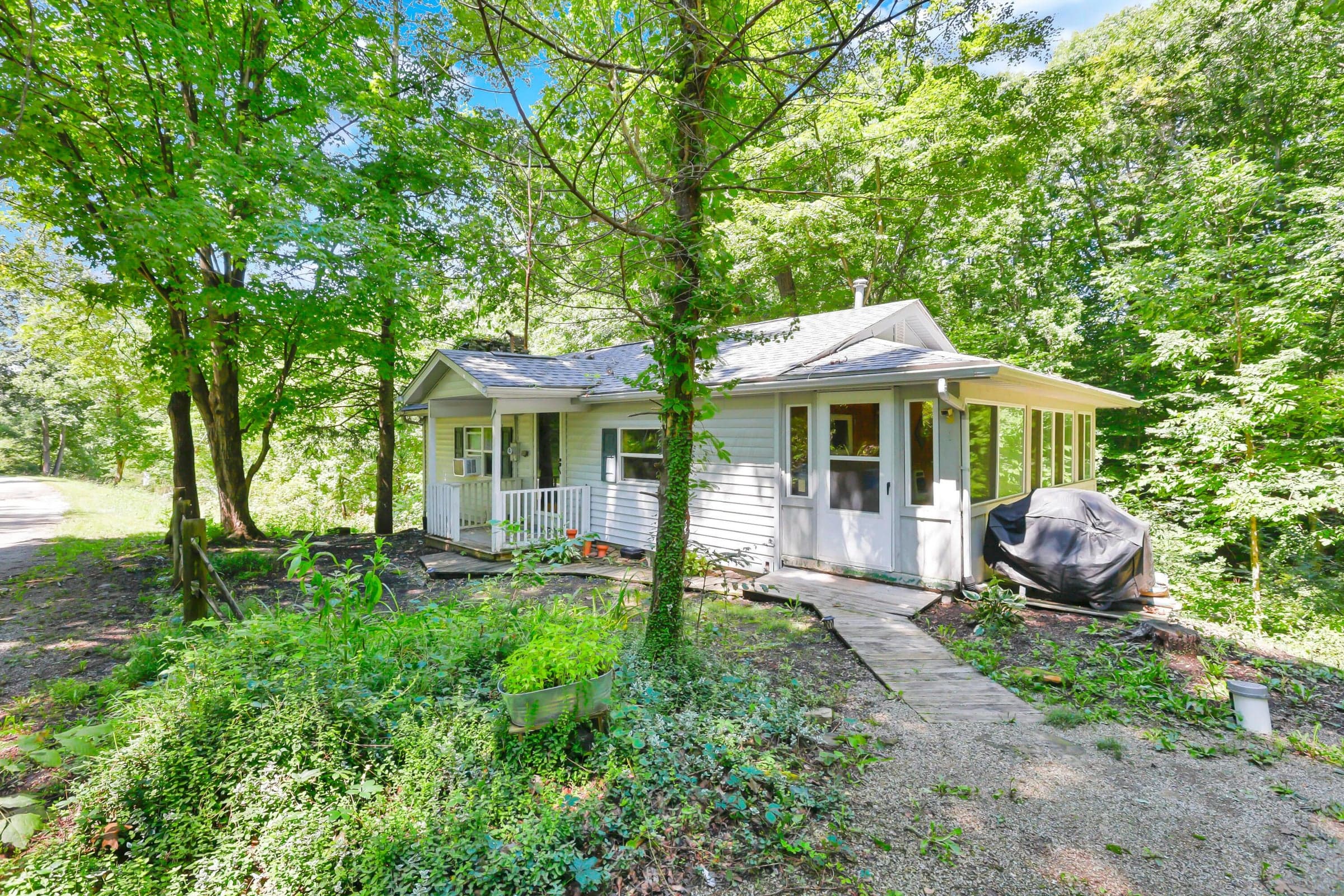 Siding exterior with a covered porch and an enclosed sunroom