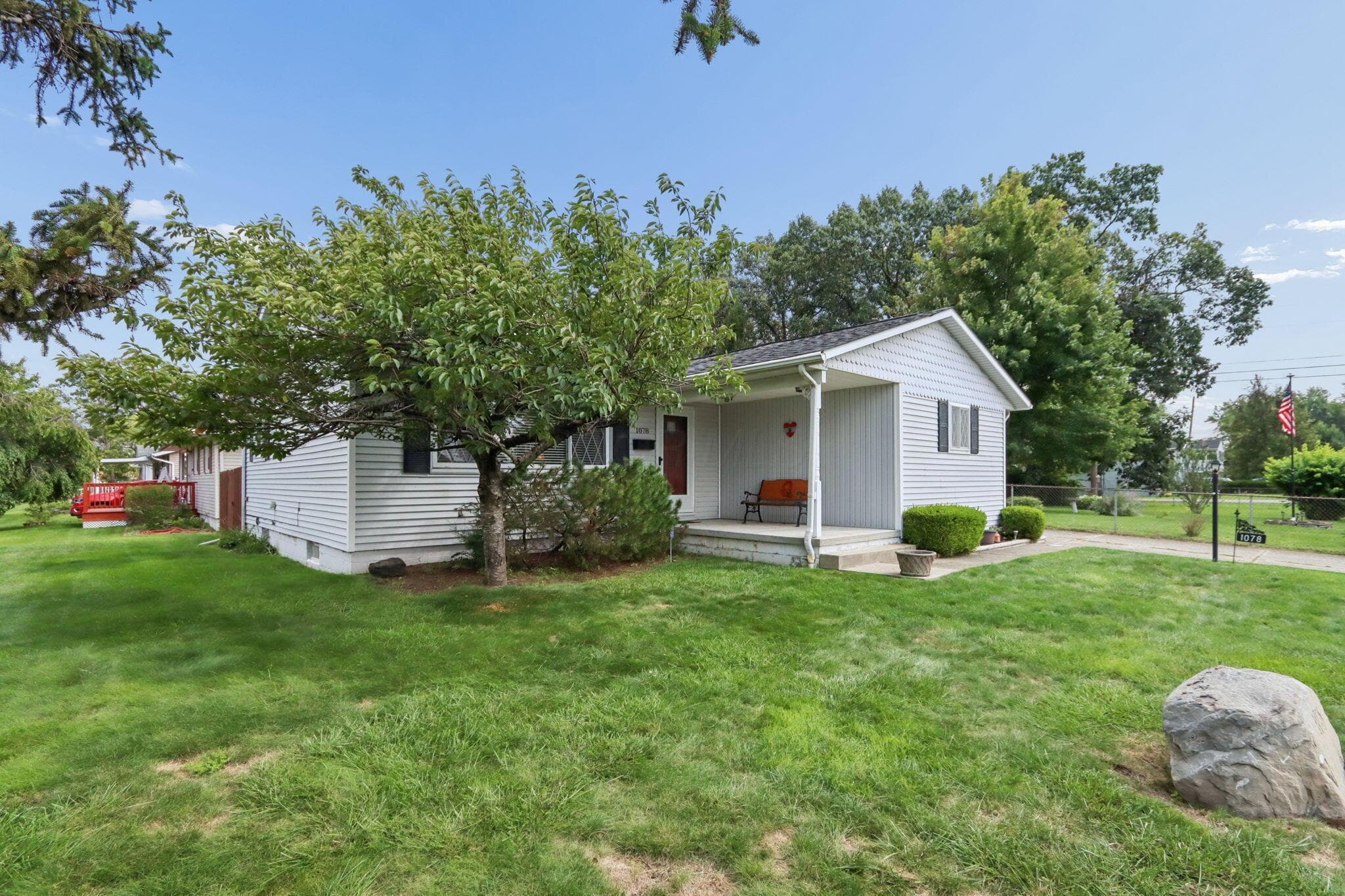 Gable-front home featuring light-colored siding and a covered porch entry