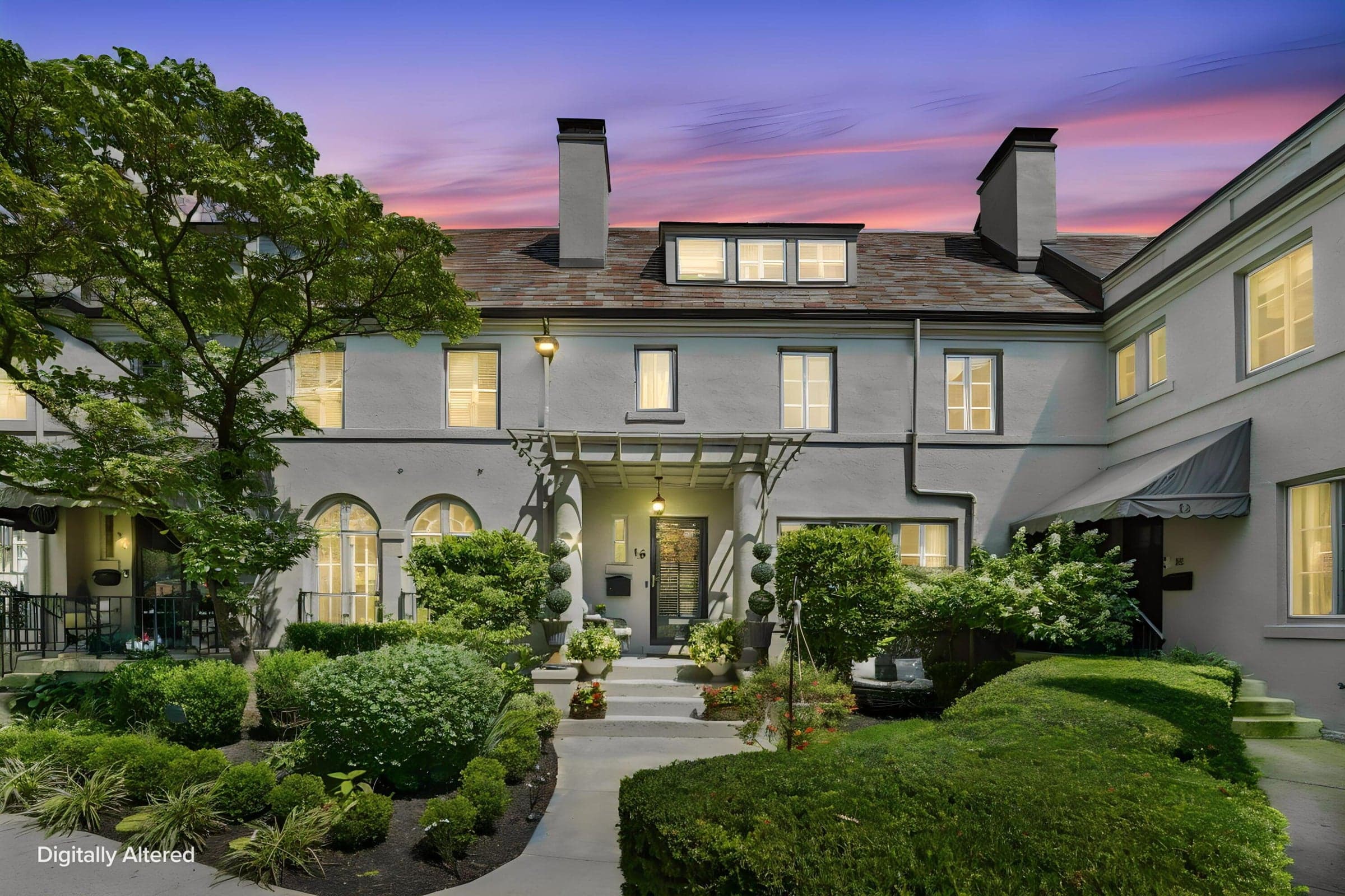 Stucco facade with multiple chimneys, prominent dormer windows, and established landscaping