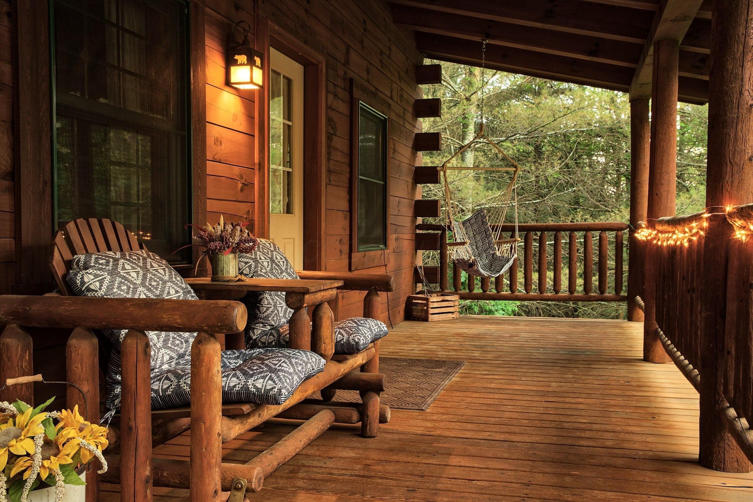 Dogwood Cabin covered front porch surrounded by the peaceful wooded setting, offering additional outdoor living and relaxation space.