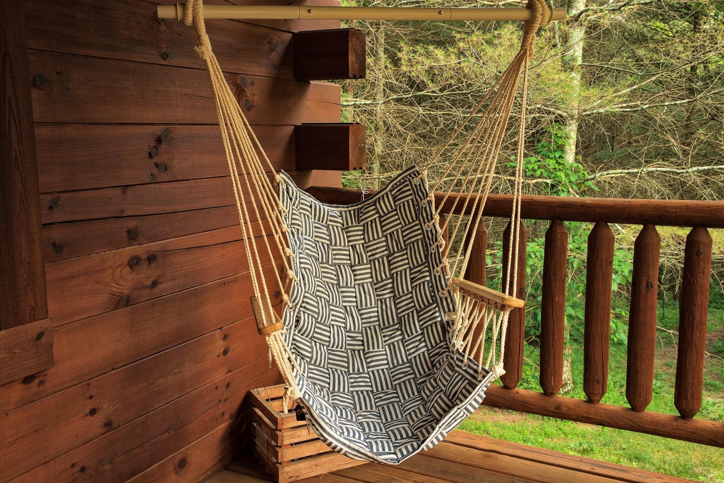 Hanging porch chair creates an inviting spot to unwind and take in the natural setting.