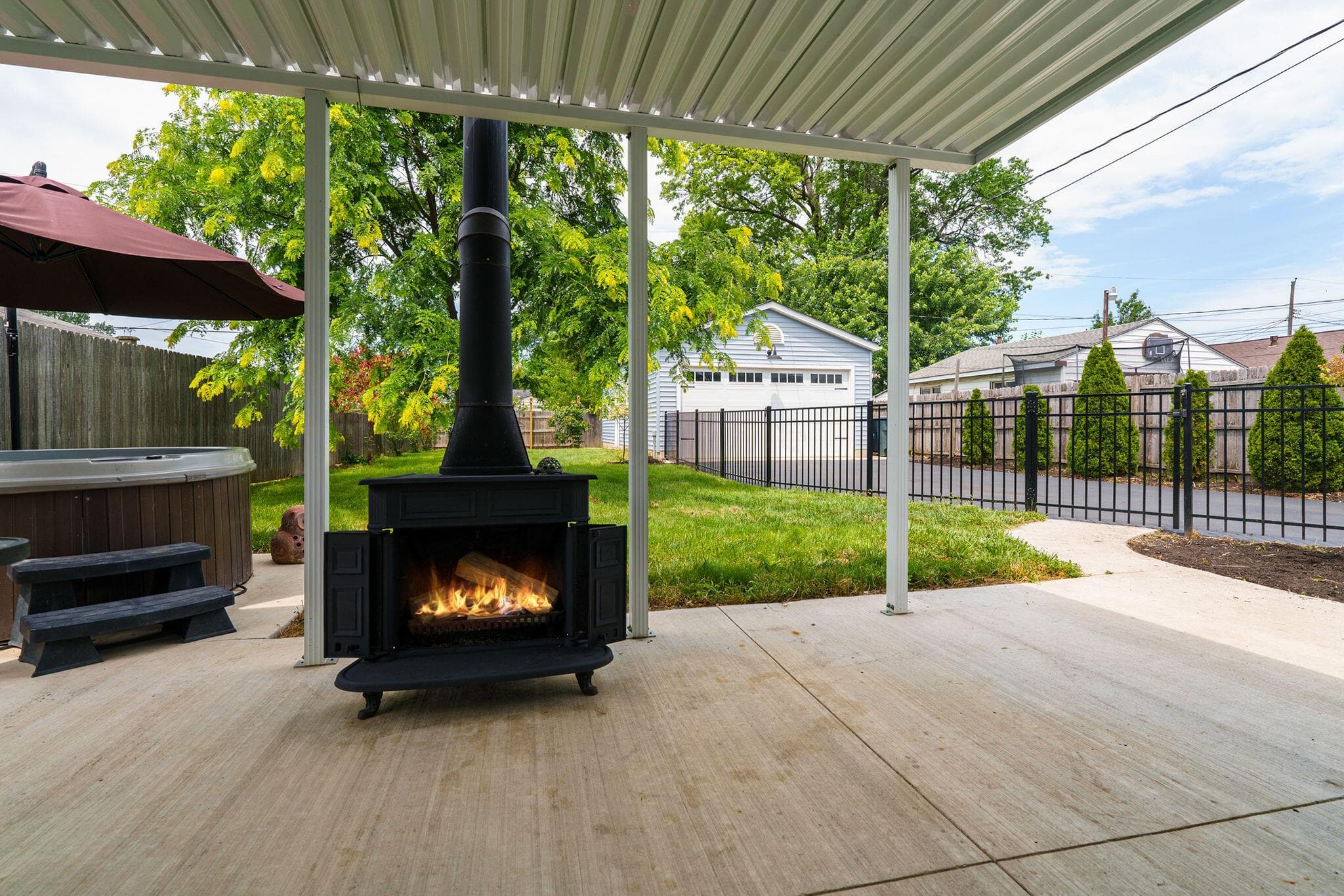 Extend living space to the fenced backyard with covered concrete patio, enhanced with a wood burning stove.
