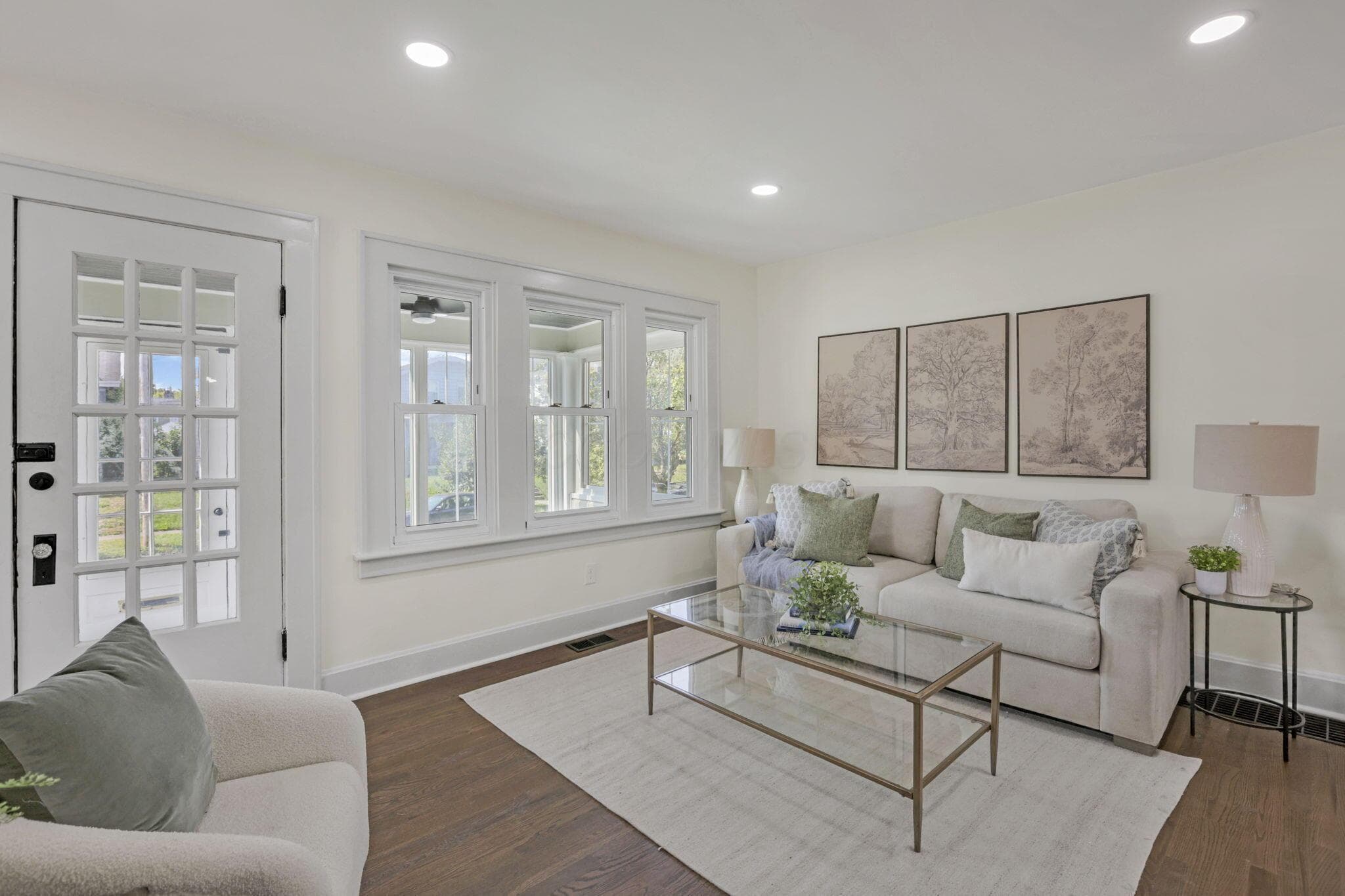 Wood-finish flooring, recessed lighting, white trim, and a multi-pane glass door