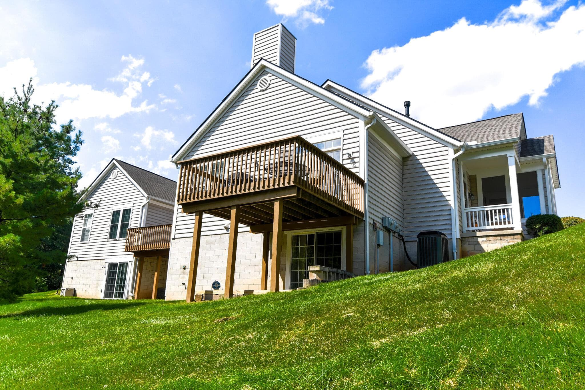 Elevated rear deck with wood railing, walkout lower-level