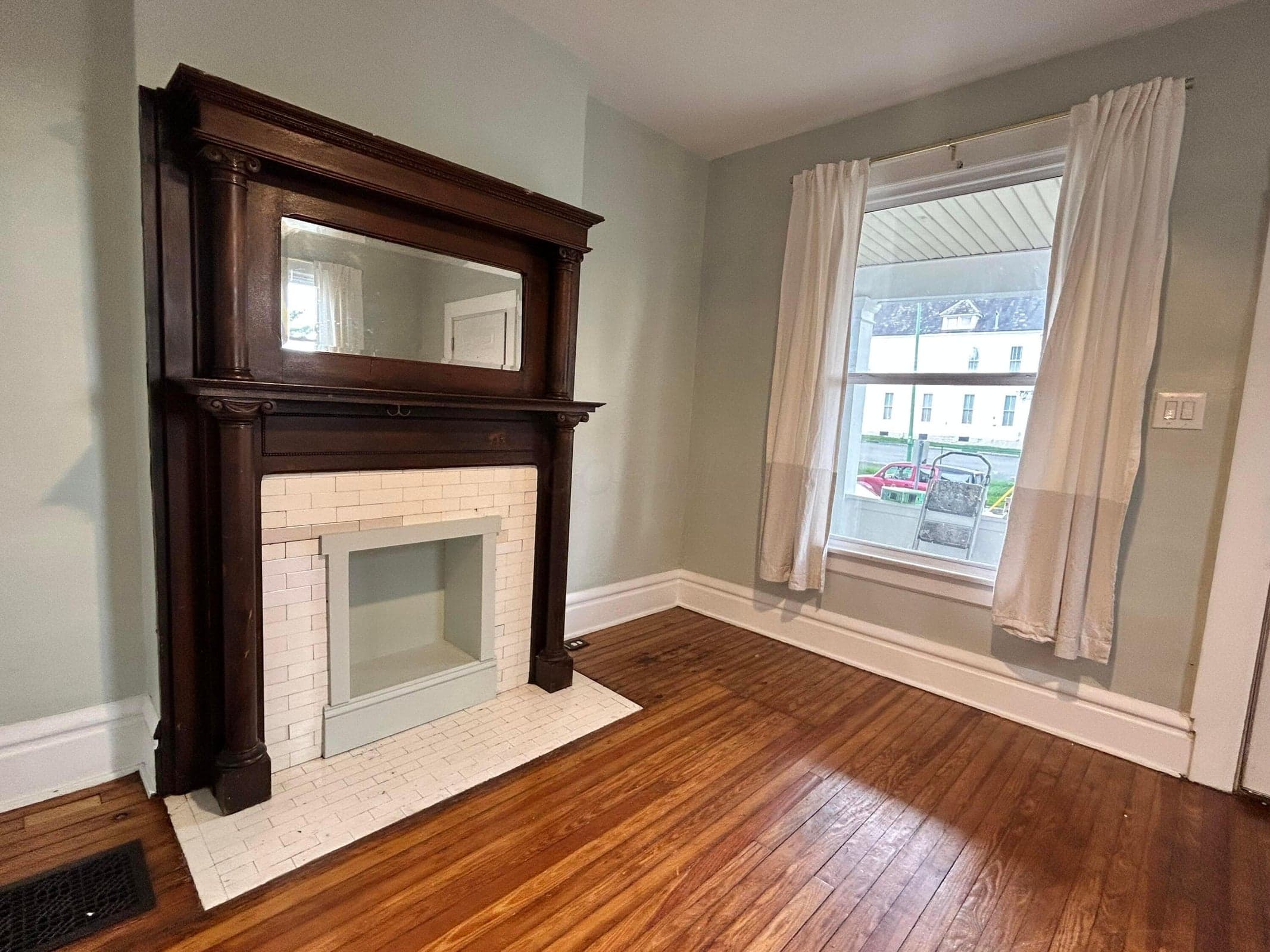 28- Hardwood flooring, decorative fireplace with tiled surround, built-in mirror on mantel.