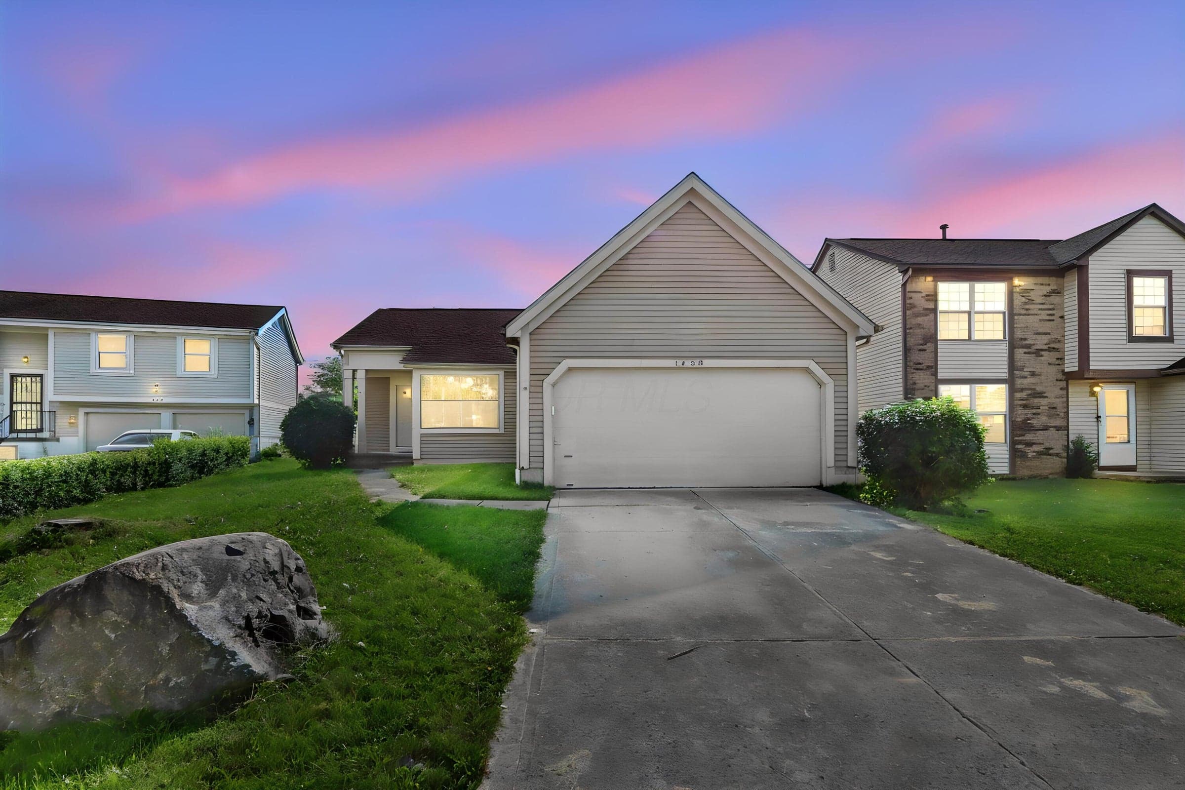 Attached one-car garage, concrete driveway, and front yard landscaping