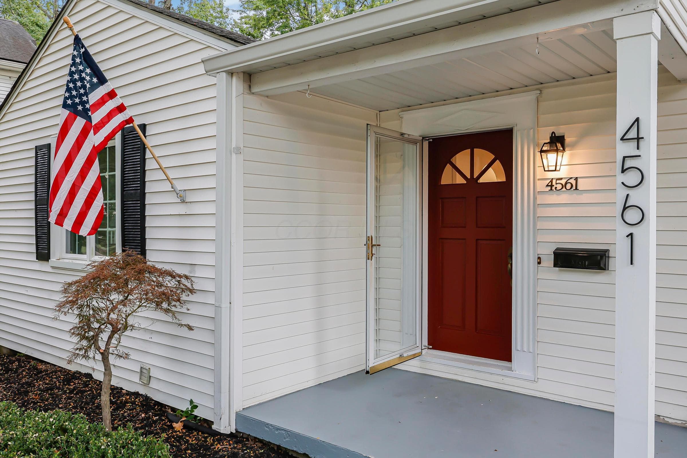 White horizontal siding with black window shutters