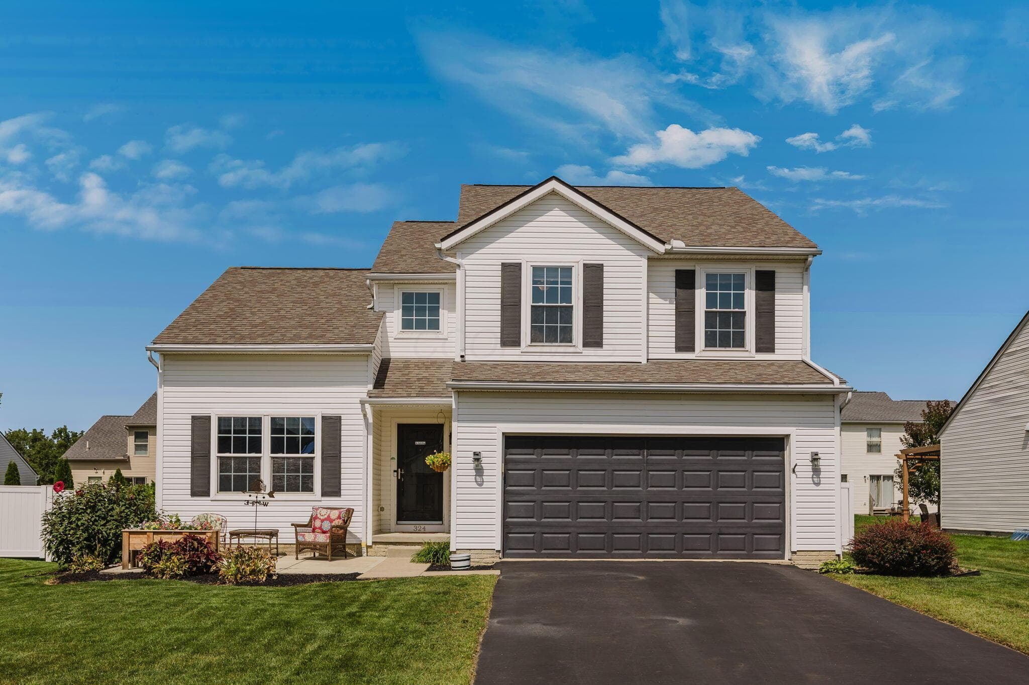 Two-story colonial exterior with white siding and dark shutters