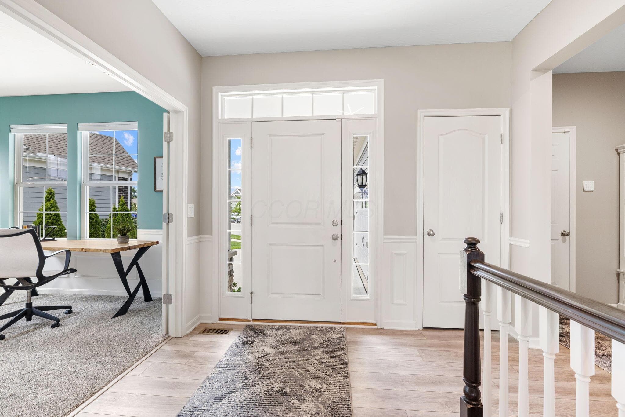Entryway with wood-finish flooring, white paneled door, and sidelight windows