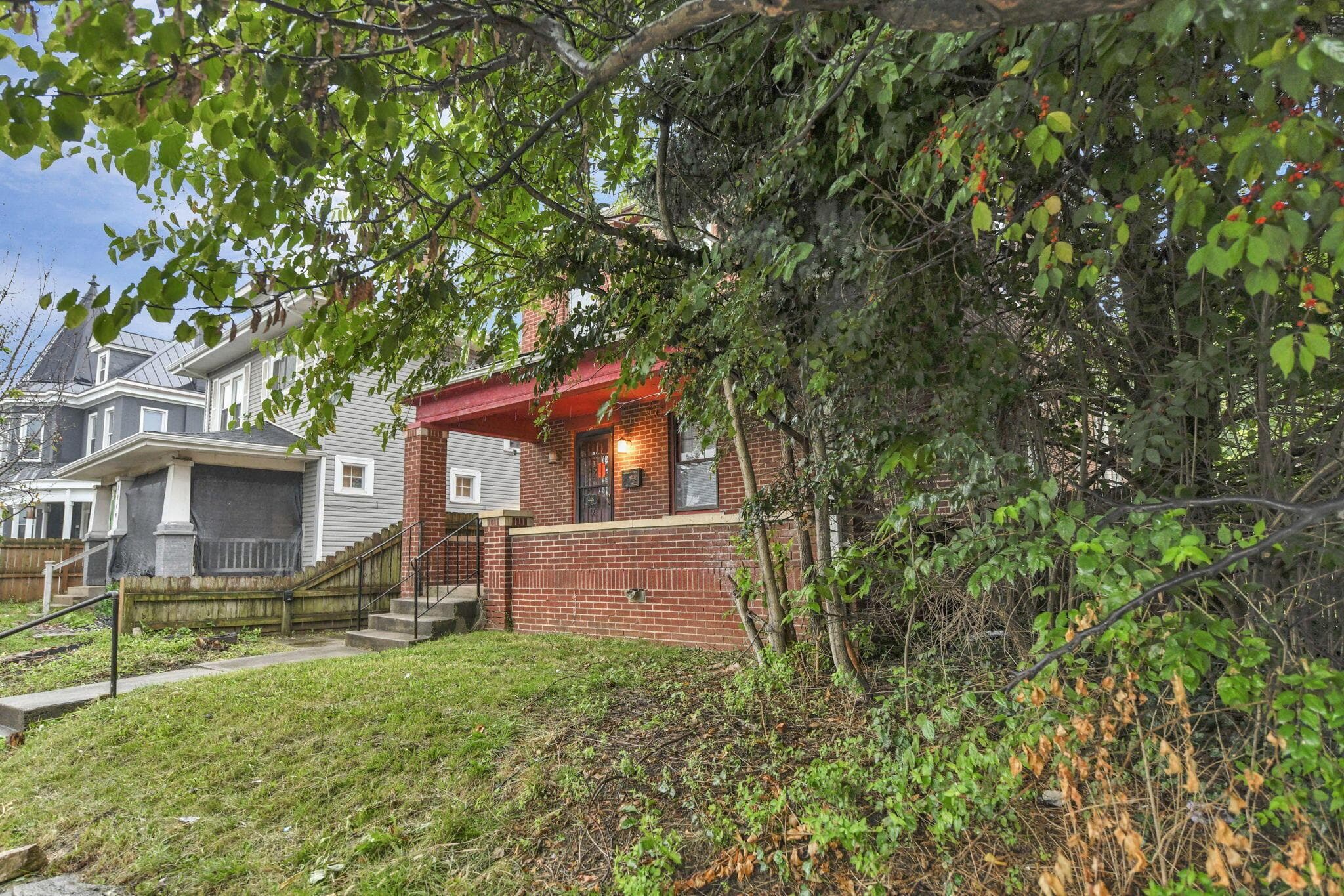 Brick facade with a covered front porch featuring a red ceiling