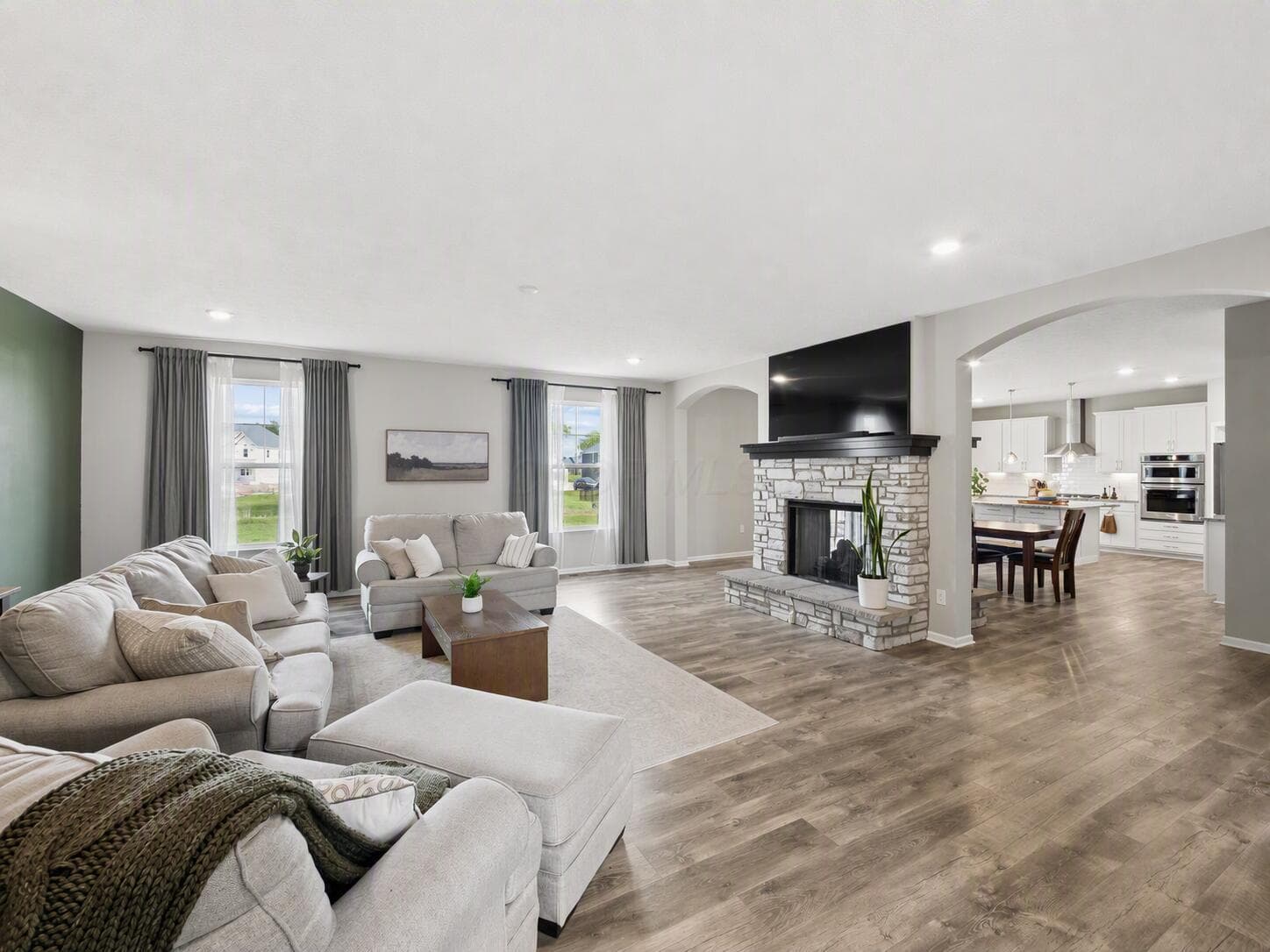 Spacious family room with fireplace and windows that bring in natural light