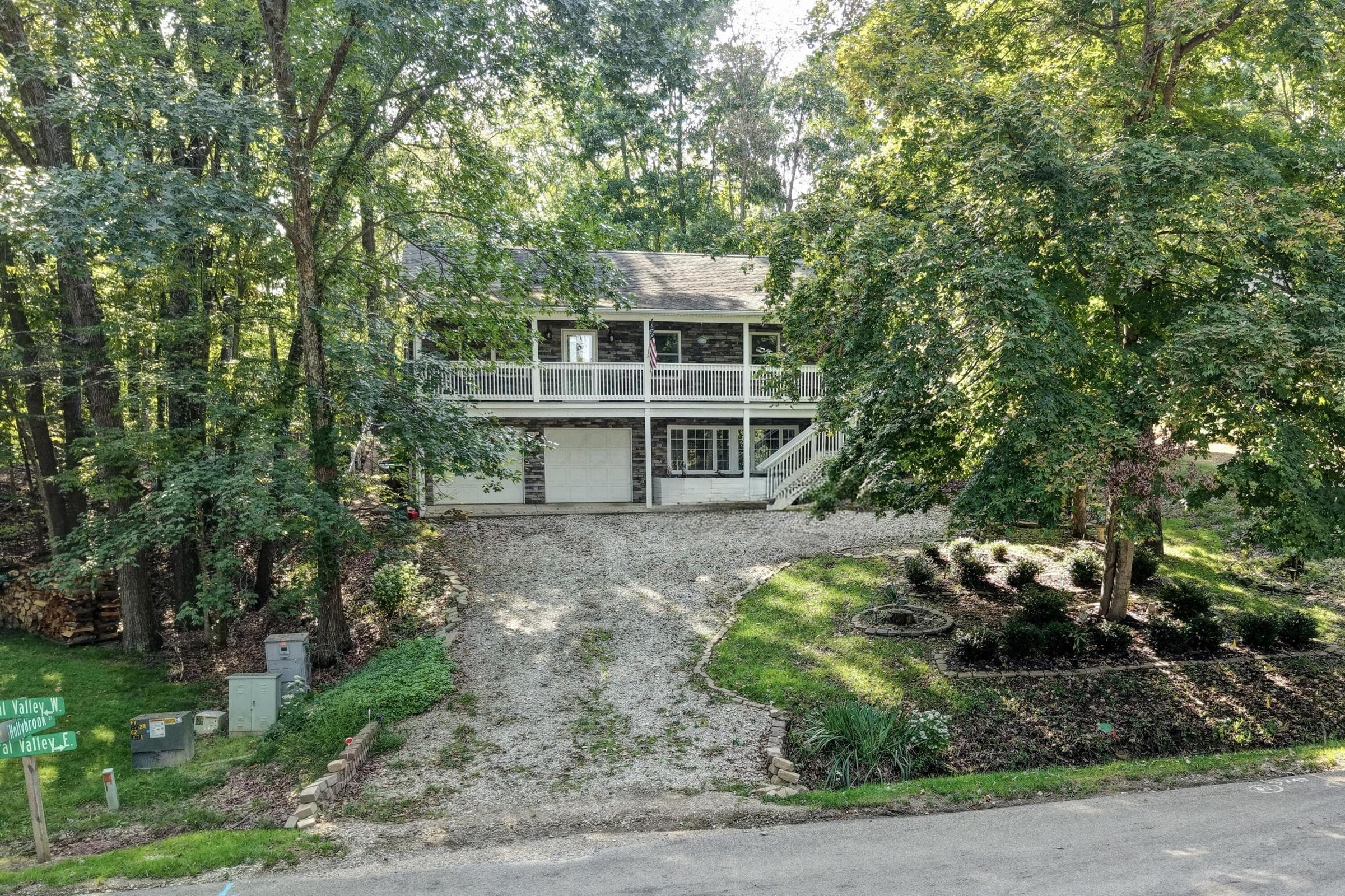 Two-story residence with a prominent second-level balcony and a ground-level patio