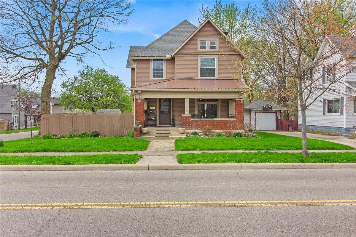 Two-story residence featuring a covered front porch, brick foundation, and siding exterior
